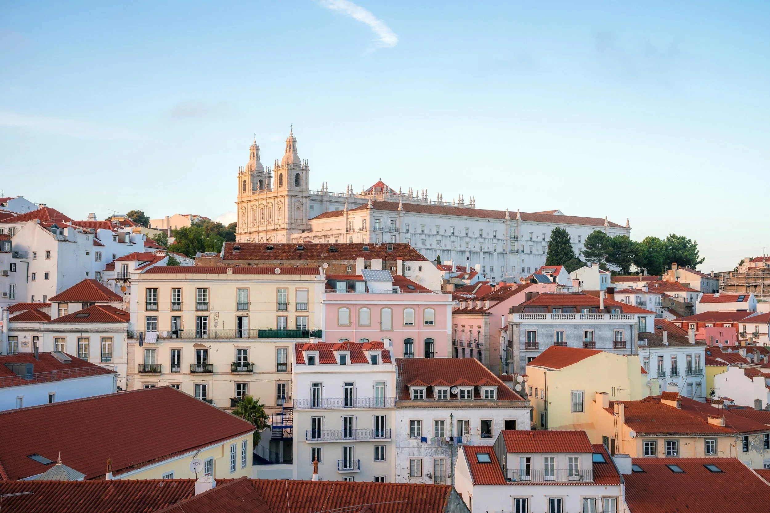 Panoramic city view of Lisbon, Portugal featuring colorful buildings, a destination recommended by Travel by Angela