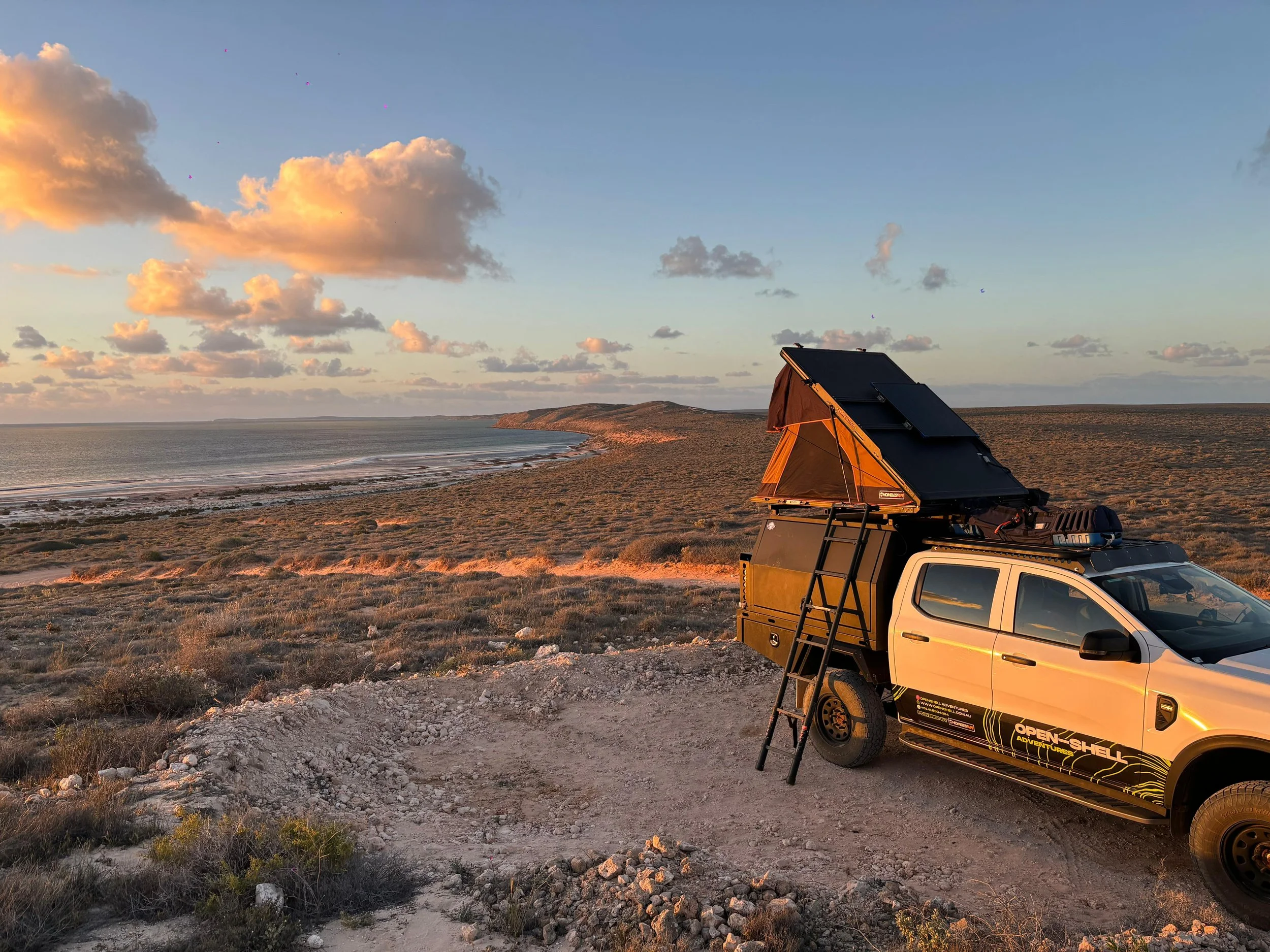 Open Shell Adventures 4WD camper set up at a remote WA beach, rooftop tent open and awning extended, perfect for off-grid coastal camping and Perth 4x4 hire seekers.