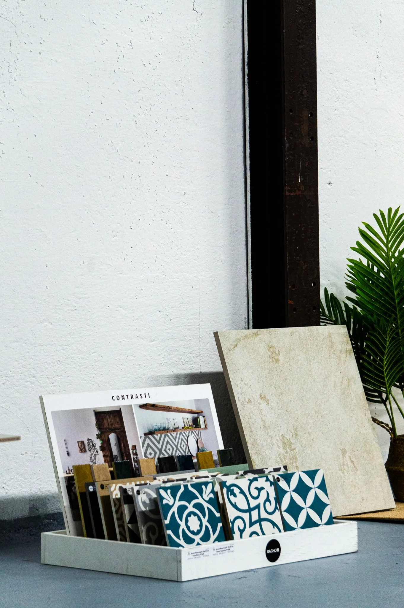 Musterkacheln und Kataloge für Innenarchitektur in einem weißen Regal im Raum. Aufgenommen von Hilal Studios.