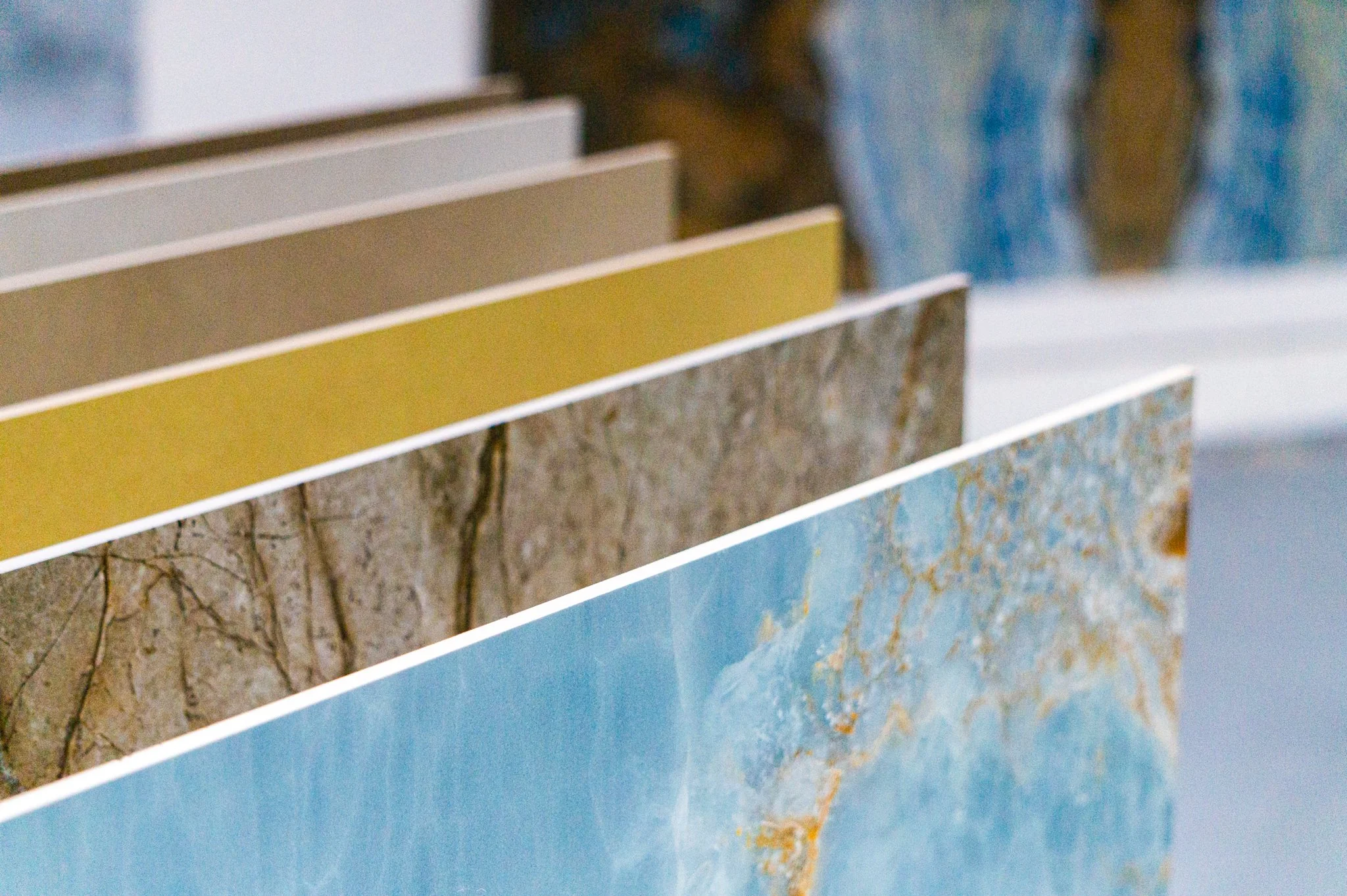 Mehrere Platten mit verschiedenen Stein- und Marmormustern, die nach Farbe und Textur angeordnet sind. Aufgenommen von Hilal Studios.