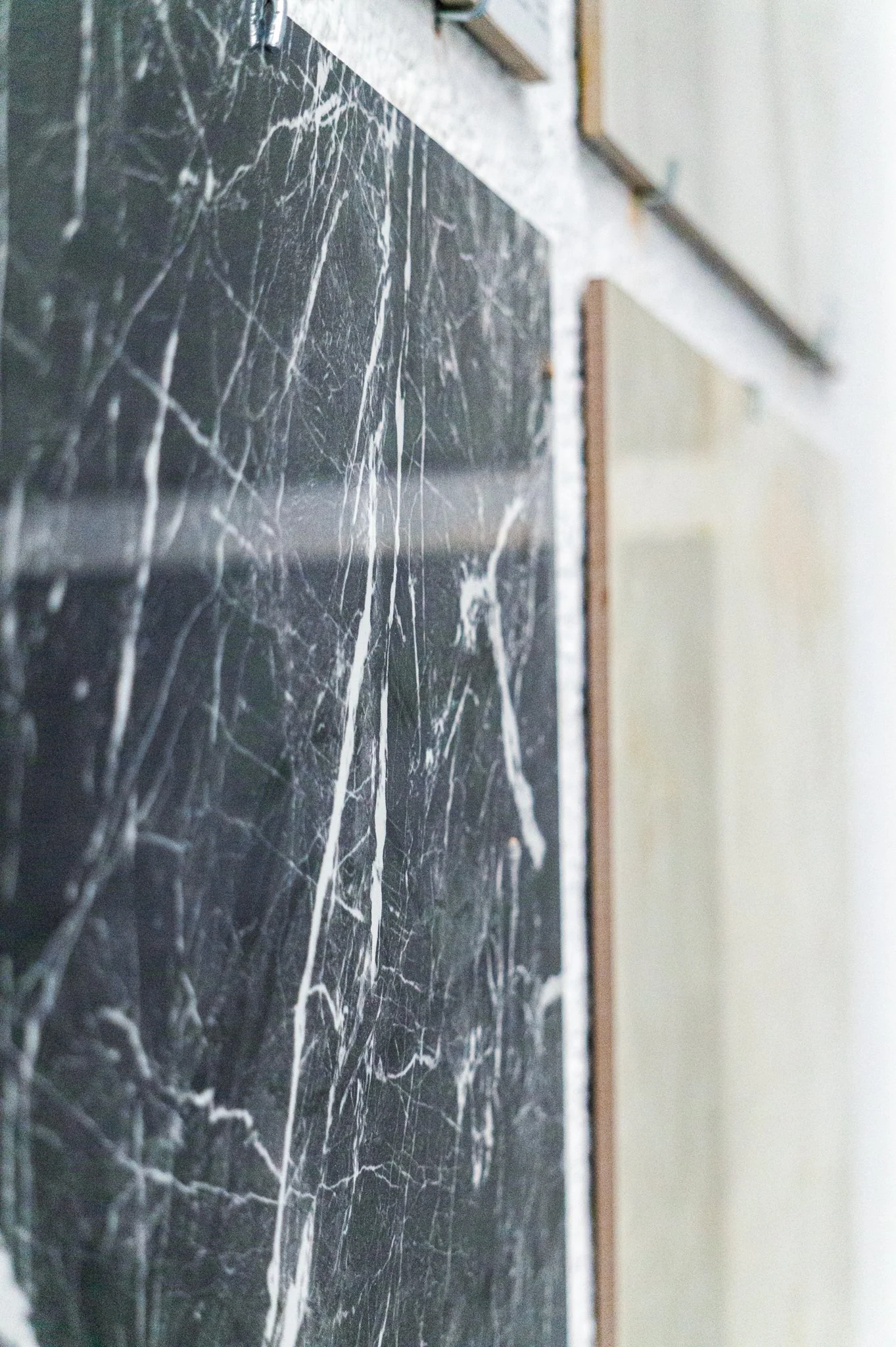 Schwarze Marmorplatte mit weißen Adern in einem Baumarkt. Aufgenommen von Hilal Studios.