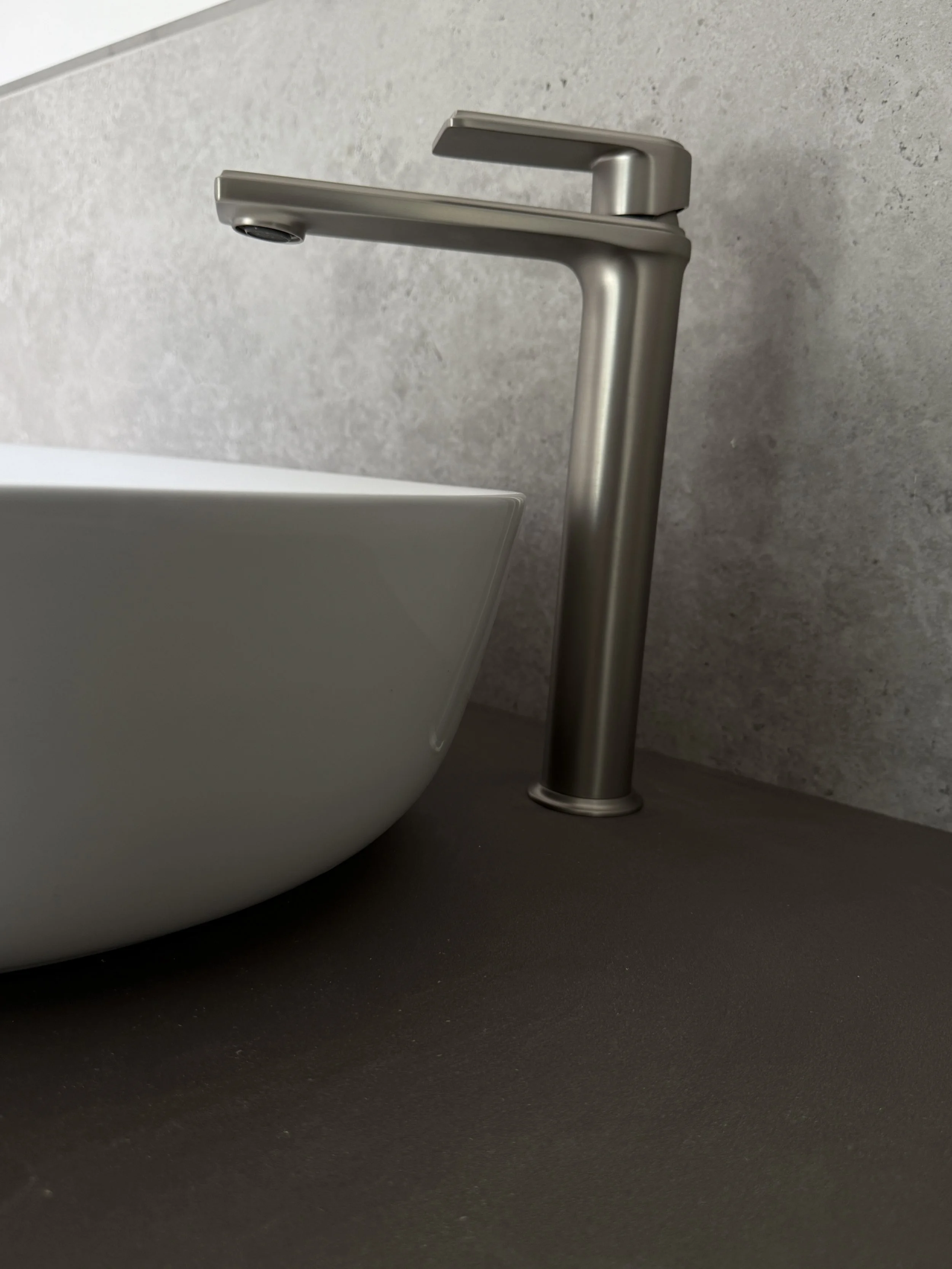 Nahaufnahme eines weißen Waschbeckens und einer modernen Edelstahlarmatur in einem Badezimmer.