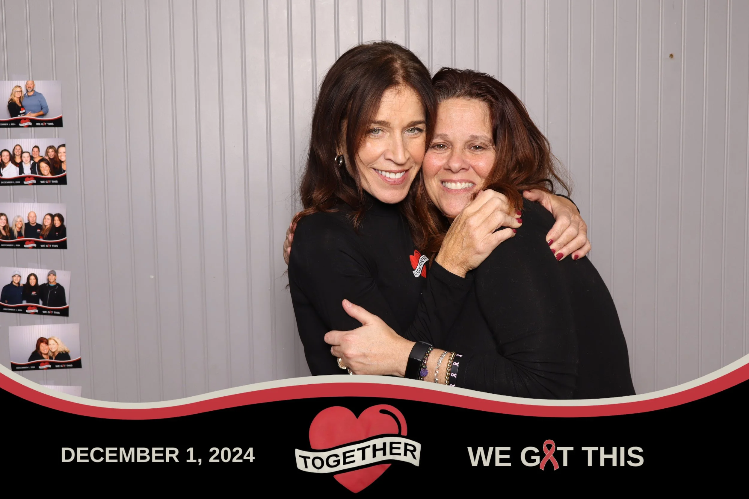 Two women with brown hair hugging and smiling, standing against a gray wall. One woman wears a black shirt with a red ribbon and the words "Together." The image includes a graphic at the bottom with the date December 1, 2024, the words "Together" with a red heart logo, and a message "We Gotta This" with a red ribbon. On the left side, there are several photo booth pictures of various groups of people.