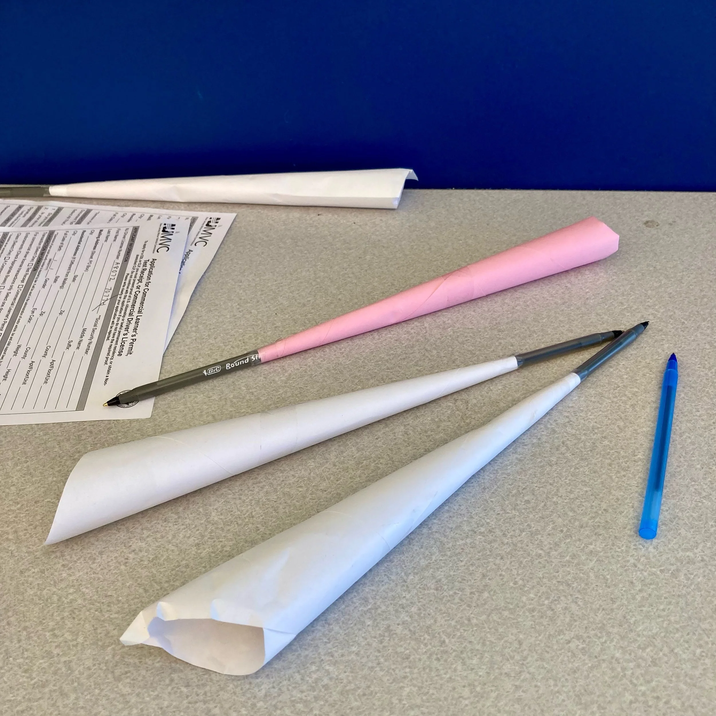 I love the low tech paper plane style pen theft protection at the DMV.