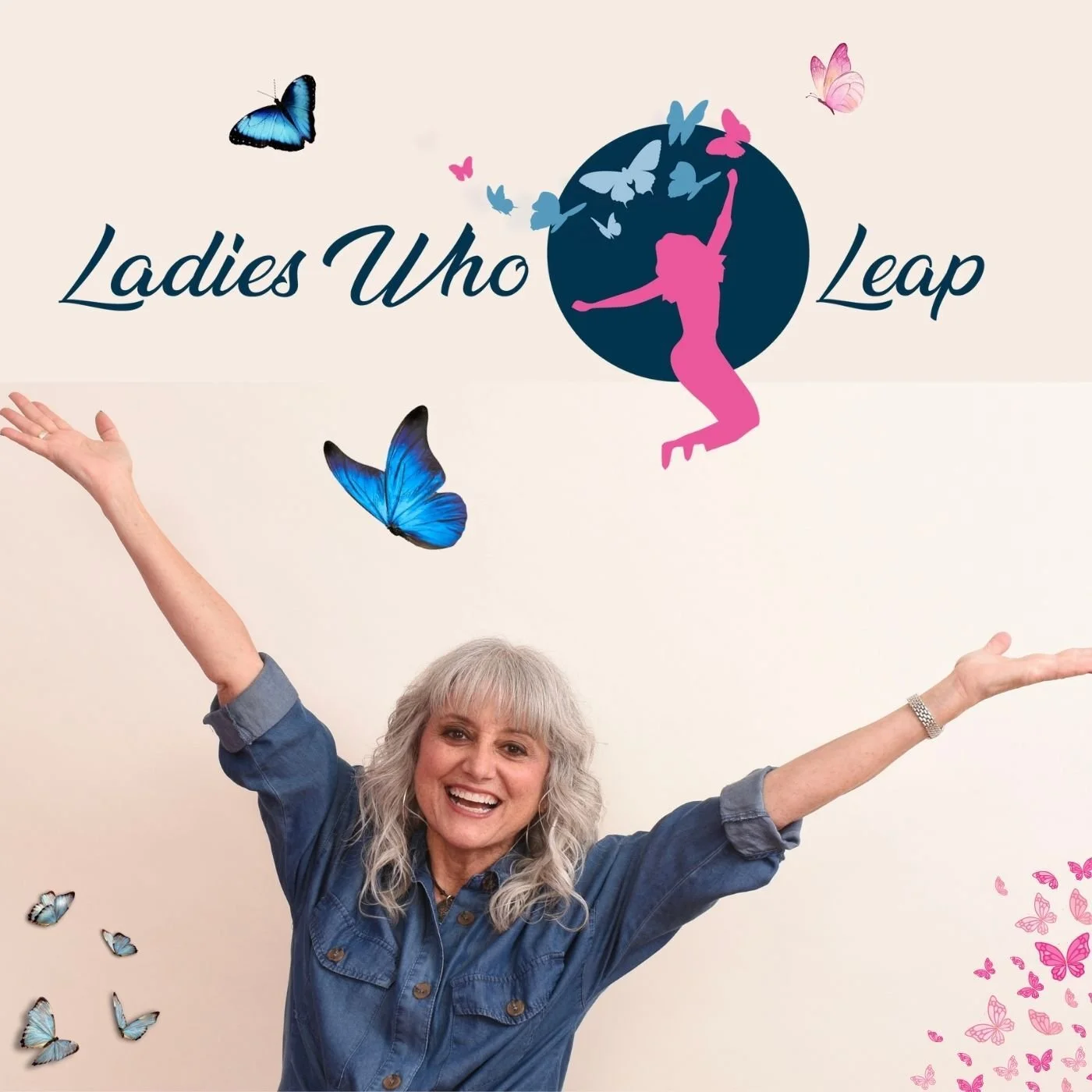 A cheerful woman with gray hair, wearing a denim shirt, raising her arms in front of a wall with the words "Ladies Who Leap" and butterfly decorations.