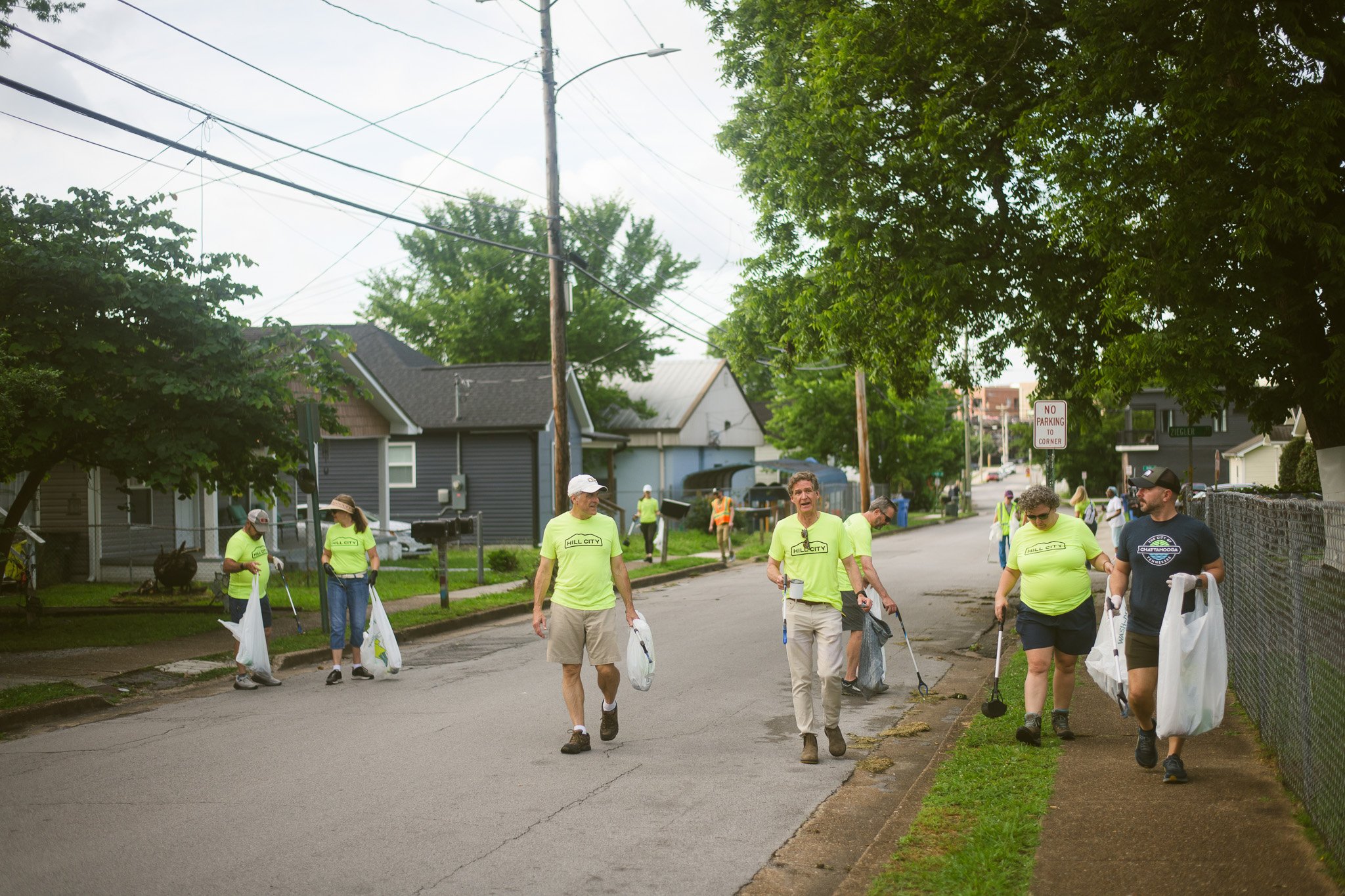 Hill City neighbors and Mayor Tim Kelly picking up trash and talking while walking along the street