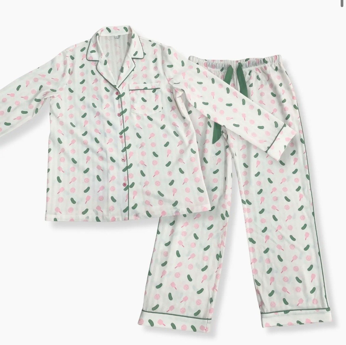 White pajamas with pink floral pattern and green leaves, button-up top, and long pants.