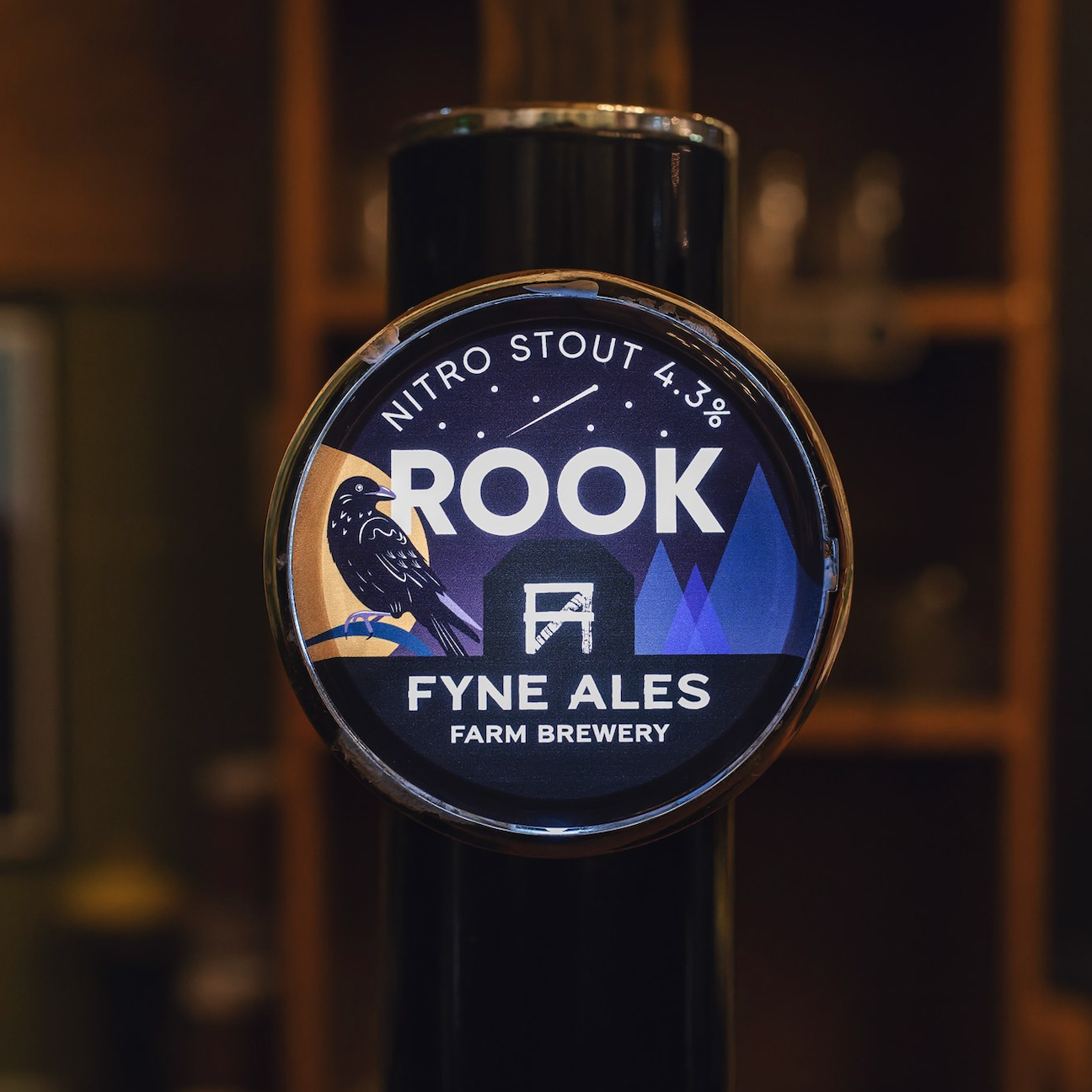 A beer tap with a label for Rook Nitro Stout from Fyne Ales, featuring a black bird and mountain graphics.