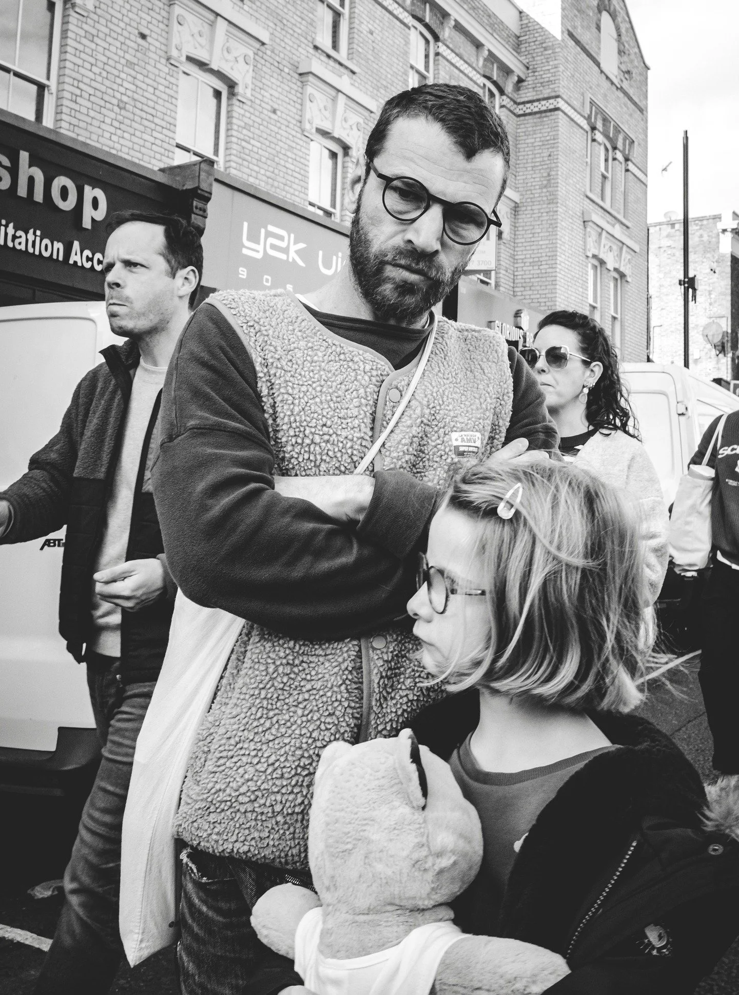 In street photography, eye contact changes everything. It pulls you out of observer mode and into the moment, suddenly you&rsquo;re not just watching, you&rsquo;re in it.

Here, a quiet stare from a father, his child tucked close, both framed by the 