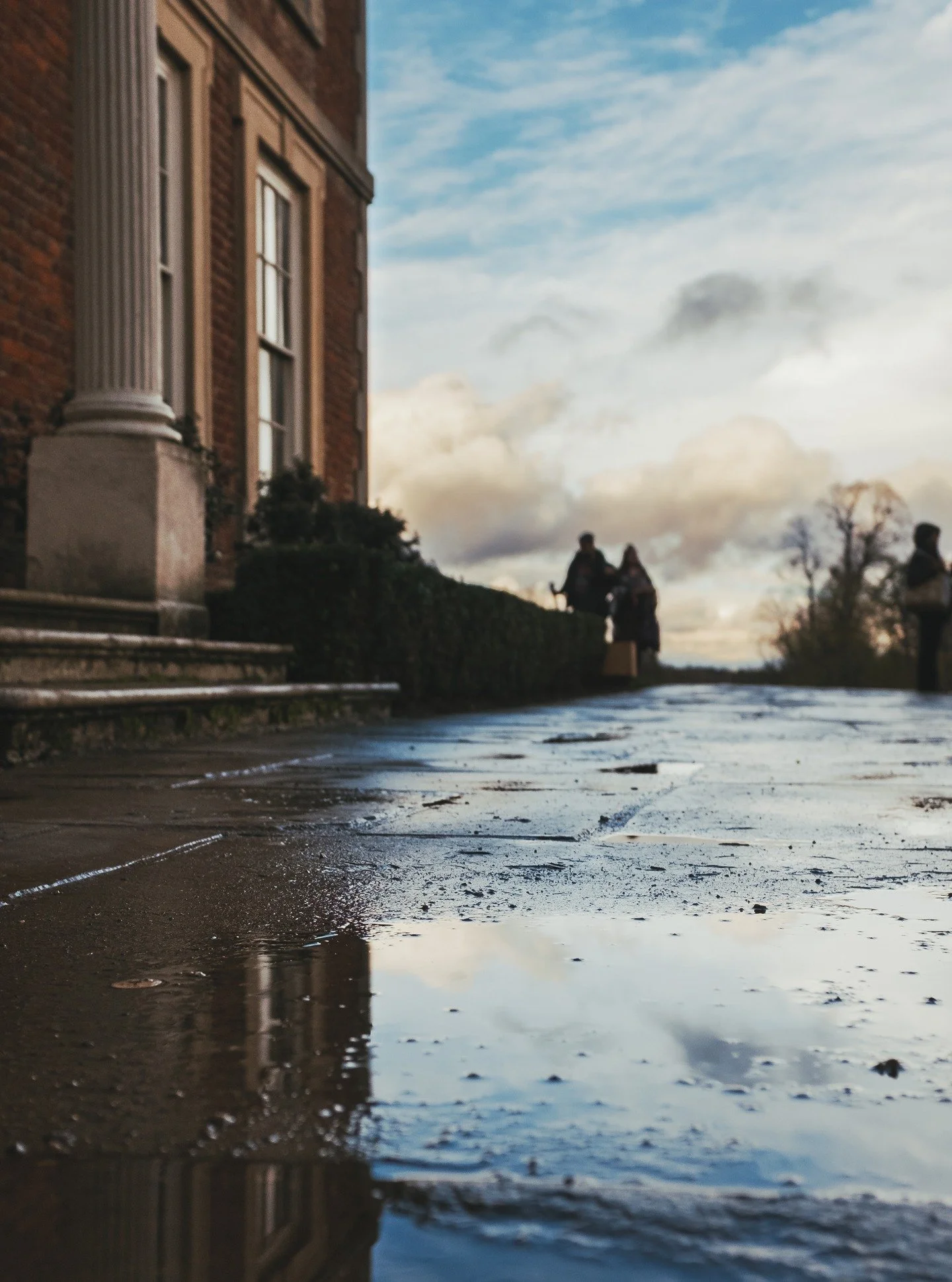 A puddle holding the sky, a path still shining from the last rain&hellip; and figures in the distance you can&rsquo;t quite place.
Forty Hall has a way of doing that, turning a simple moment into something that feels like it&rsquo;s watching you back