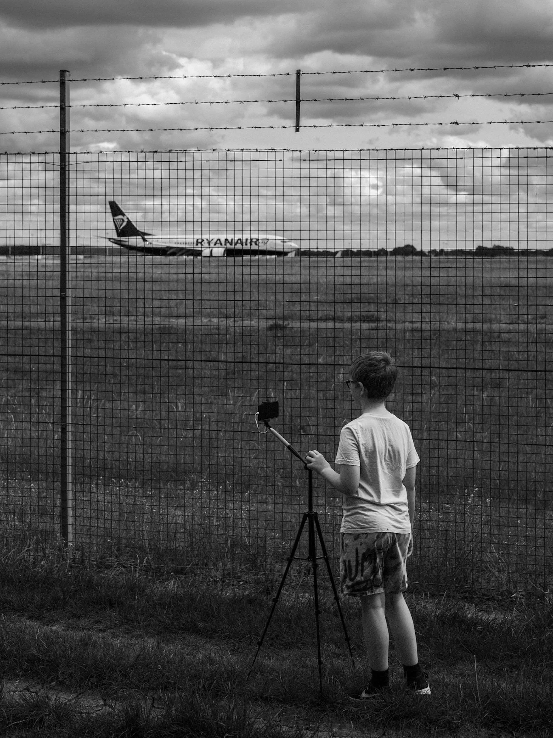 Monochrome Moment

We stood by the airport fence for over an hour.
He was waiting for planes.
I was watching him.
I&rsquo;m still not entirely sure which of us had the better time. 
#MonochromeMoments
#BlackAndWhitePhotography
#DocumentaryPhotography