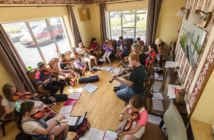 Johnny Kelly and Darach O'Connor with their young fiddle students.