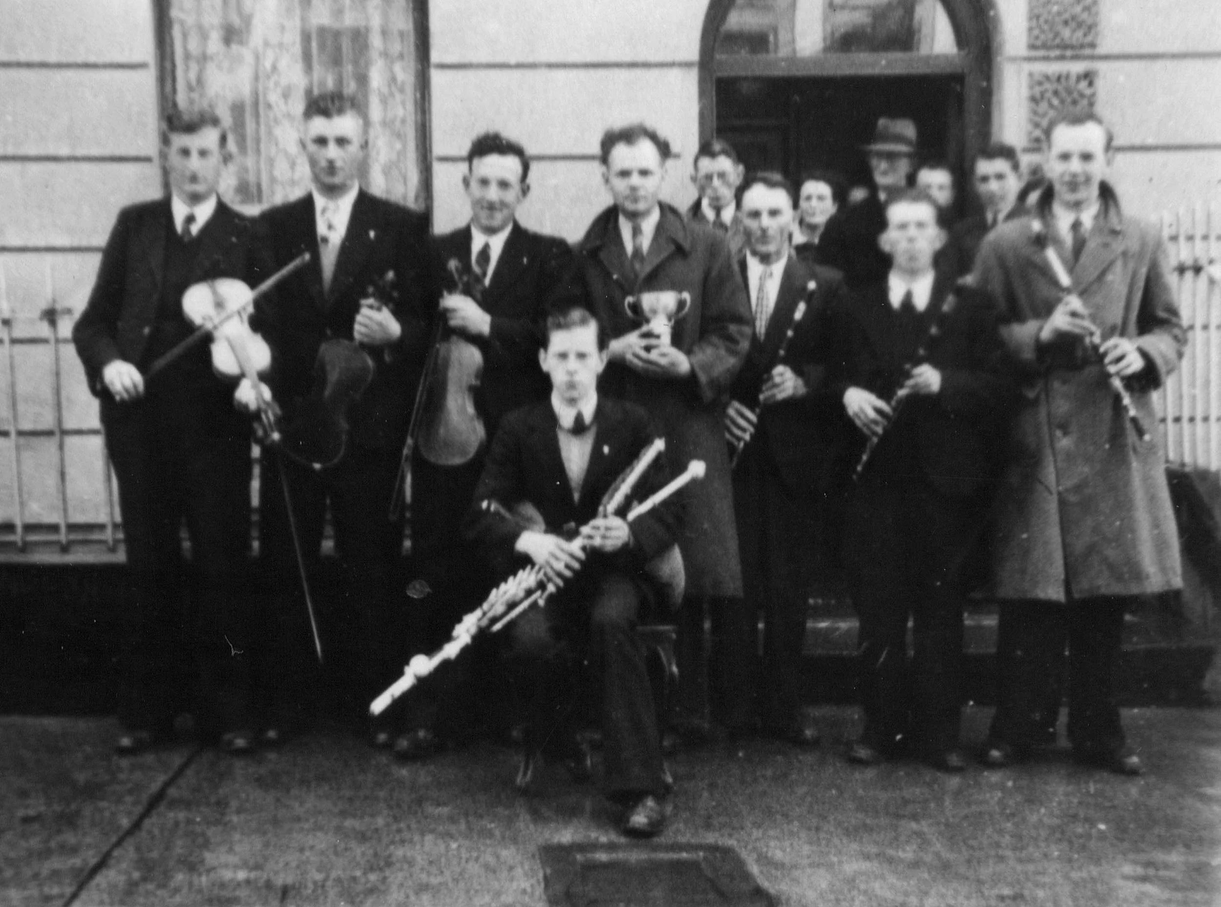 The Tulla Céilí Band pictured after winning the 1947 Oireachtas na Mumhan Prize with (l. to r.)  P. Joe Hayes, Francie Donnellan, Paddy Canny, Paddy O'Donoghue (seated), Seán Reid (holding cup), Jack Murphy, Jim O'Donoghue and Willie Clancy. 
Photo c