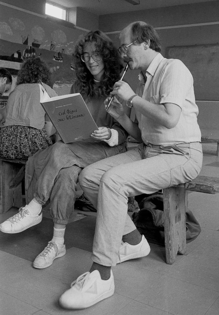 Darach de Brún (right) plays a tune for one of his whistle students, 1985.