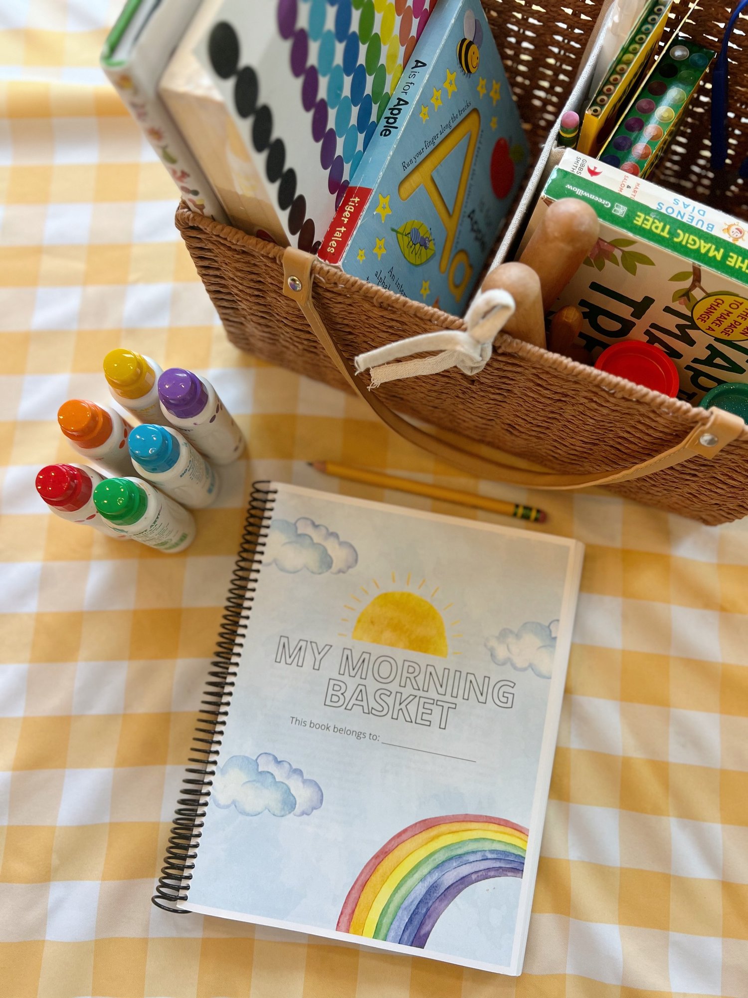 Morning basket with a spiral-bound activity book, dot markers and a rainbow coloring page