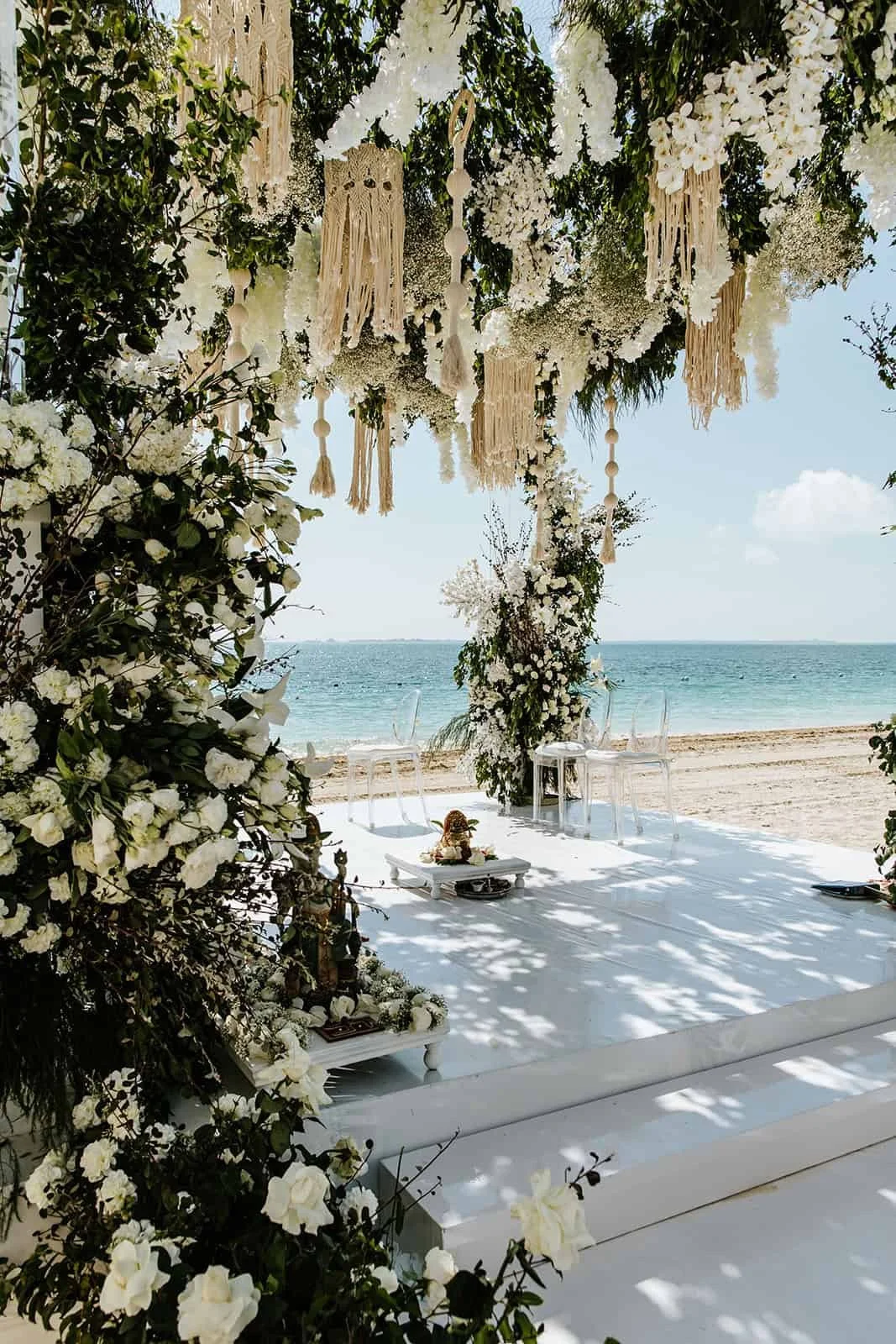 Luxury beach wedding ceremony setup in Cancun with floral arch and ocean view