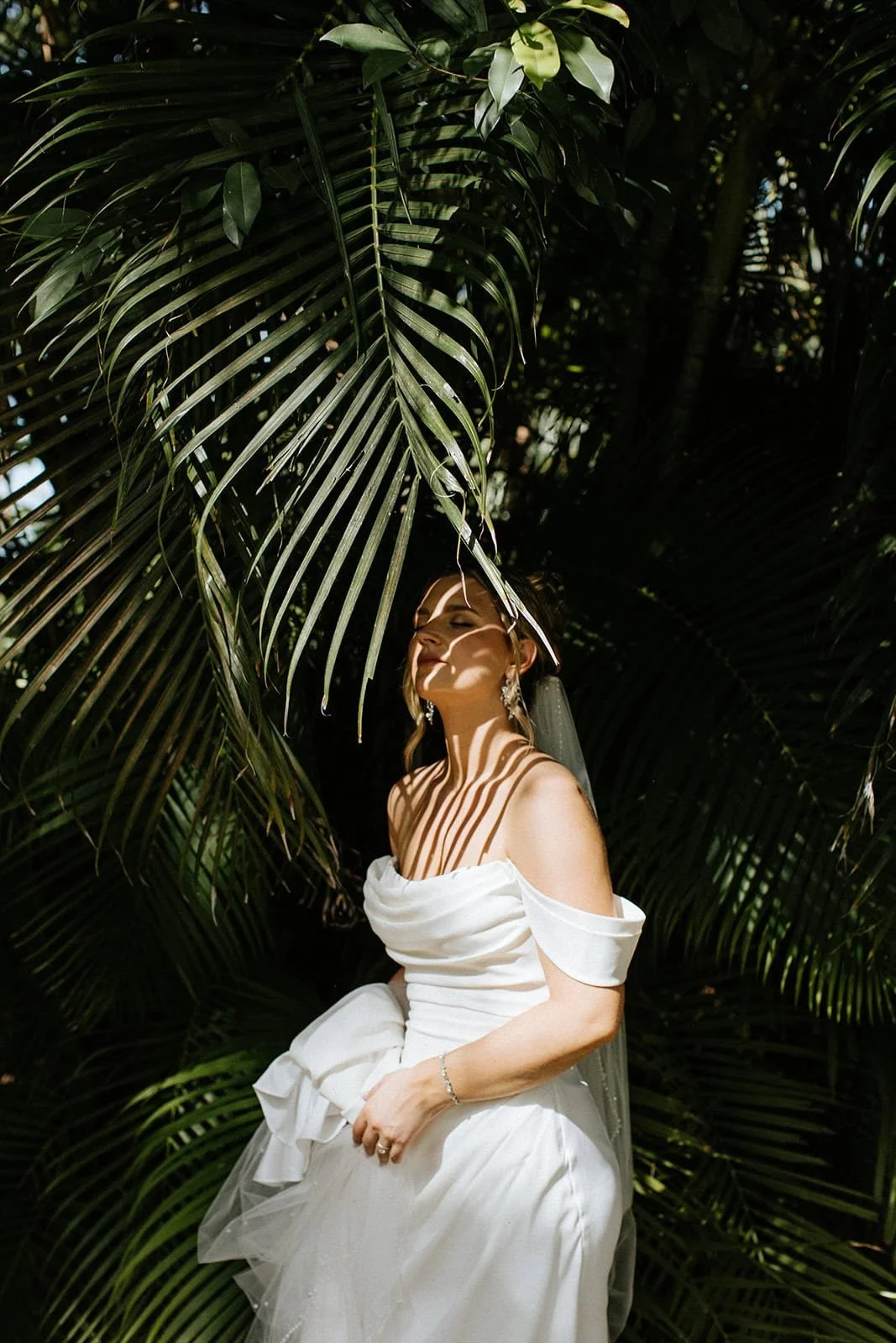 Bride portrait in tropical jungle with palm leaf shadows during a destination wedding in Cancun, Mexico