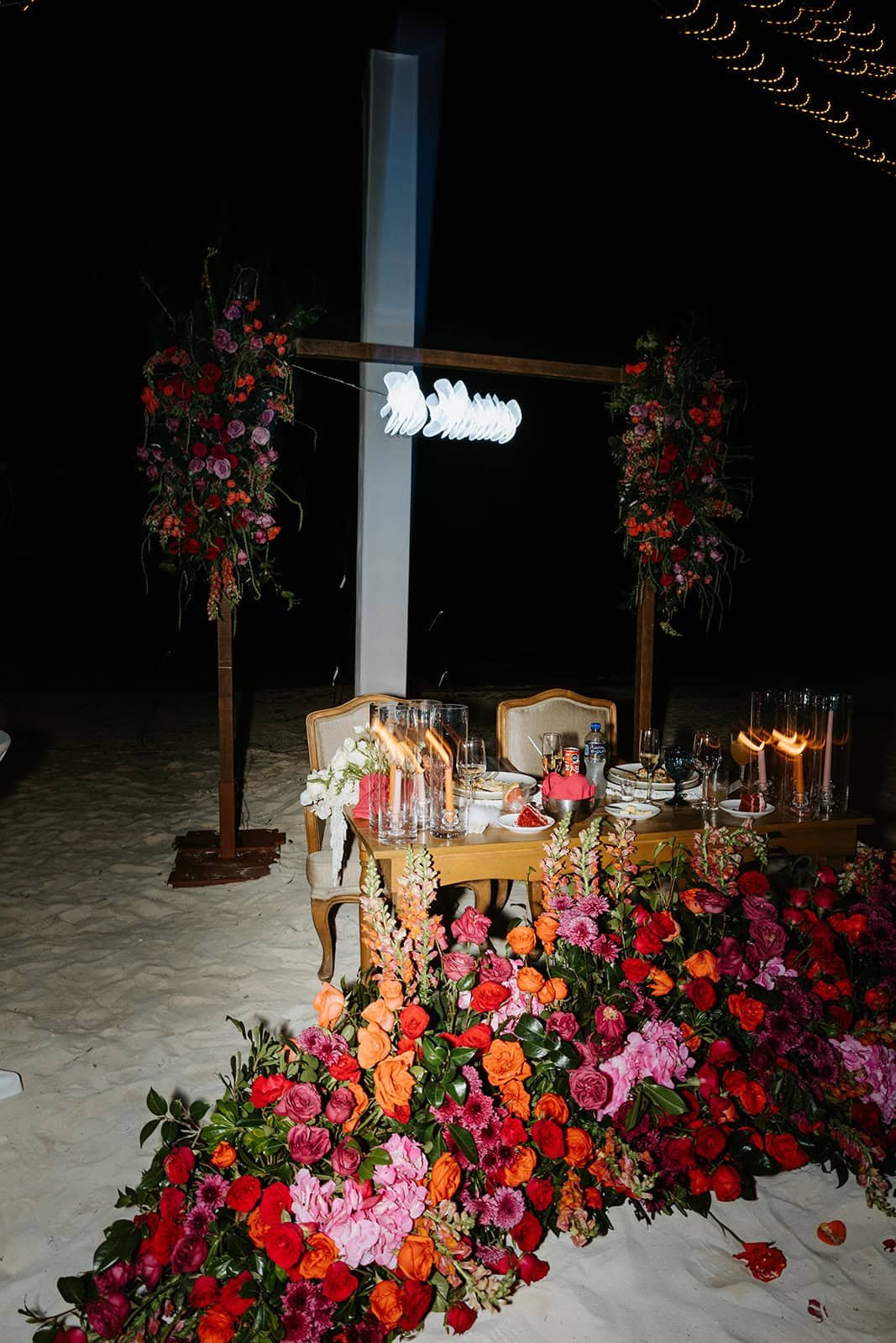 Sweetheart reception table with lush red and pink florals at Garza Blanca Cancún wedding.