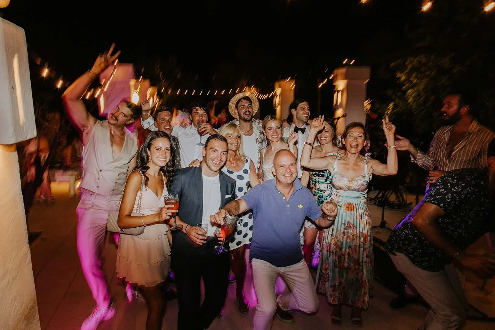 Large Group Photo Under String Lights