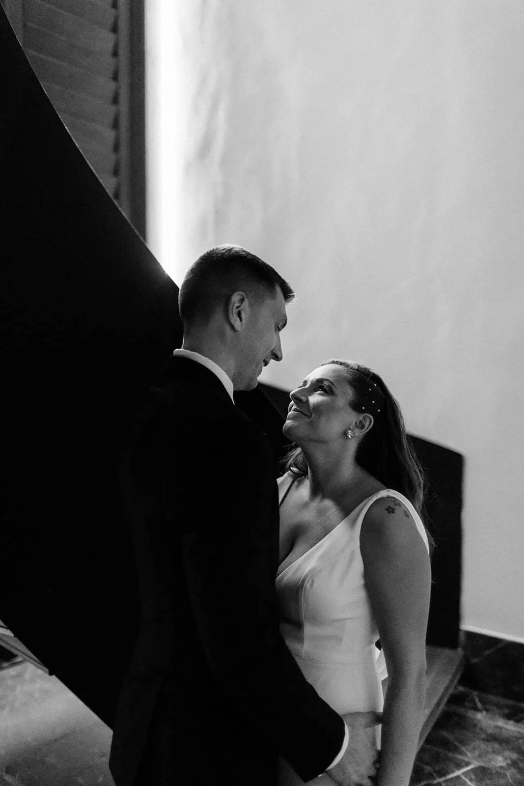 Black and white portrait of a couple looking at each other on the spiral staircase at Secrets Moxché Playa del Carmen
