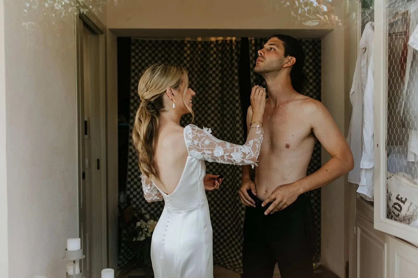 Bride in white lace dress and groom together in getting ready space at Masseria Potenti, intimate moment