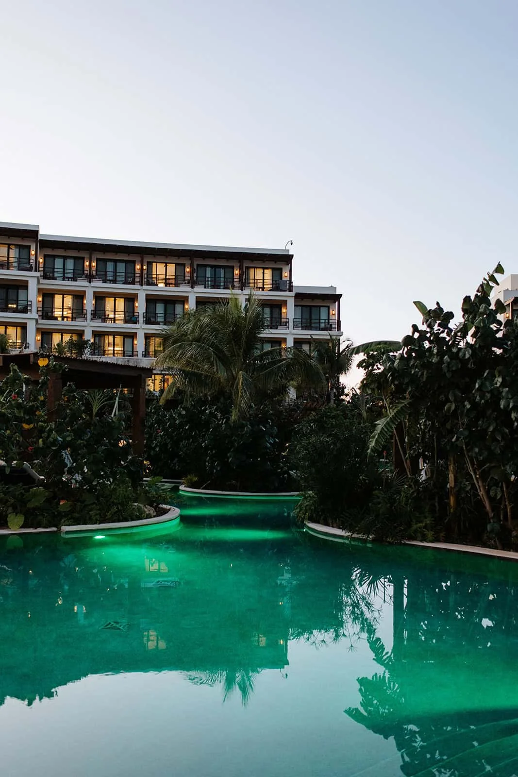 Jungle pool terrace glowing at blue hour during a wedding welcome dinner at Secrets Playa Blanca Costa Mujeres
