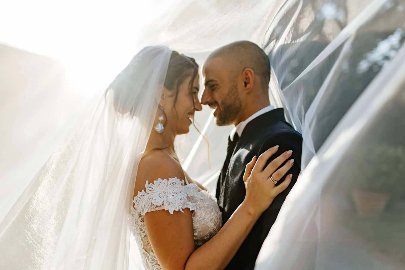 Bride and groom forehead-to-forehead intimate portrait under the bridal veil at Villa Oliva in Lucca — Italy wedding.