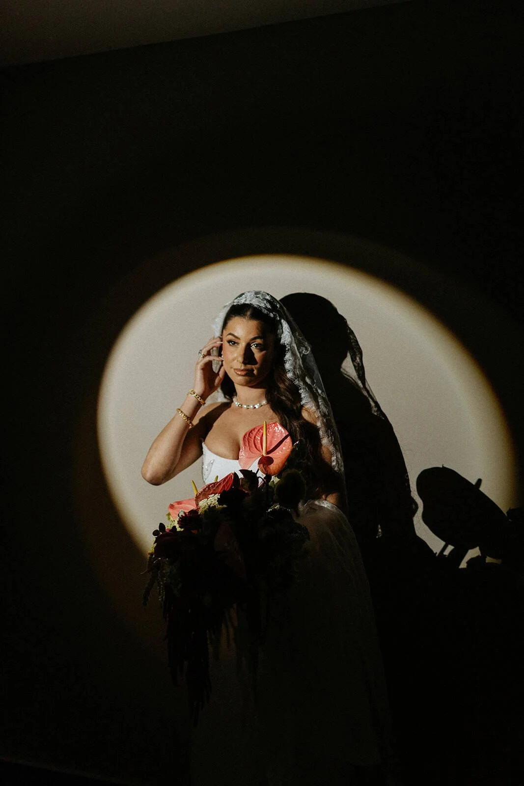 Bride in circle of light holding tropical bouquet at Persian wedding at Garza Blanca Cancún