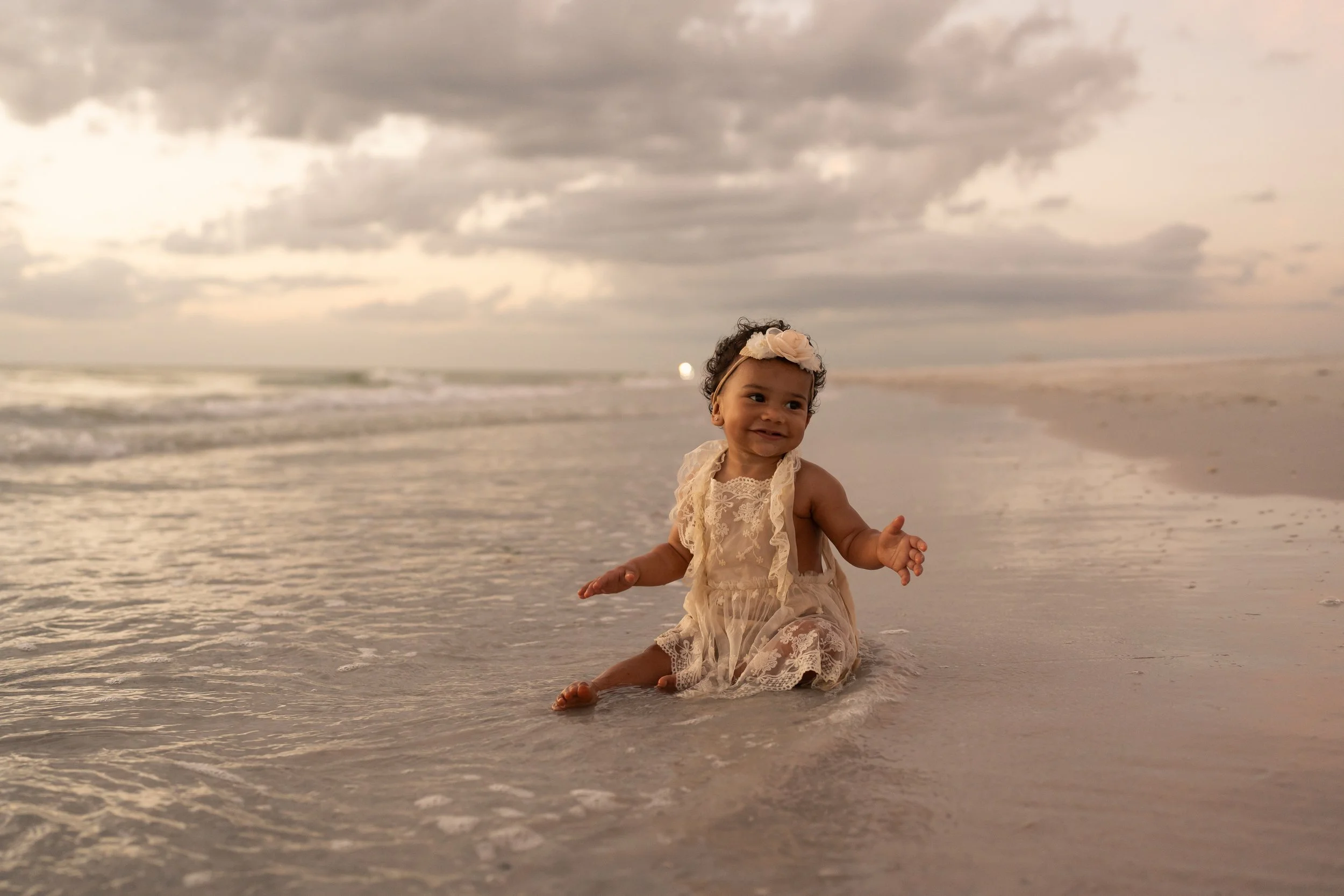 Cozy room with person holding mug, seated on couch, lit candle on table, potted plant in background.