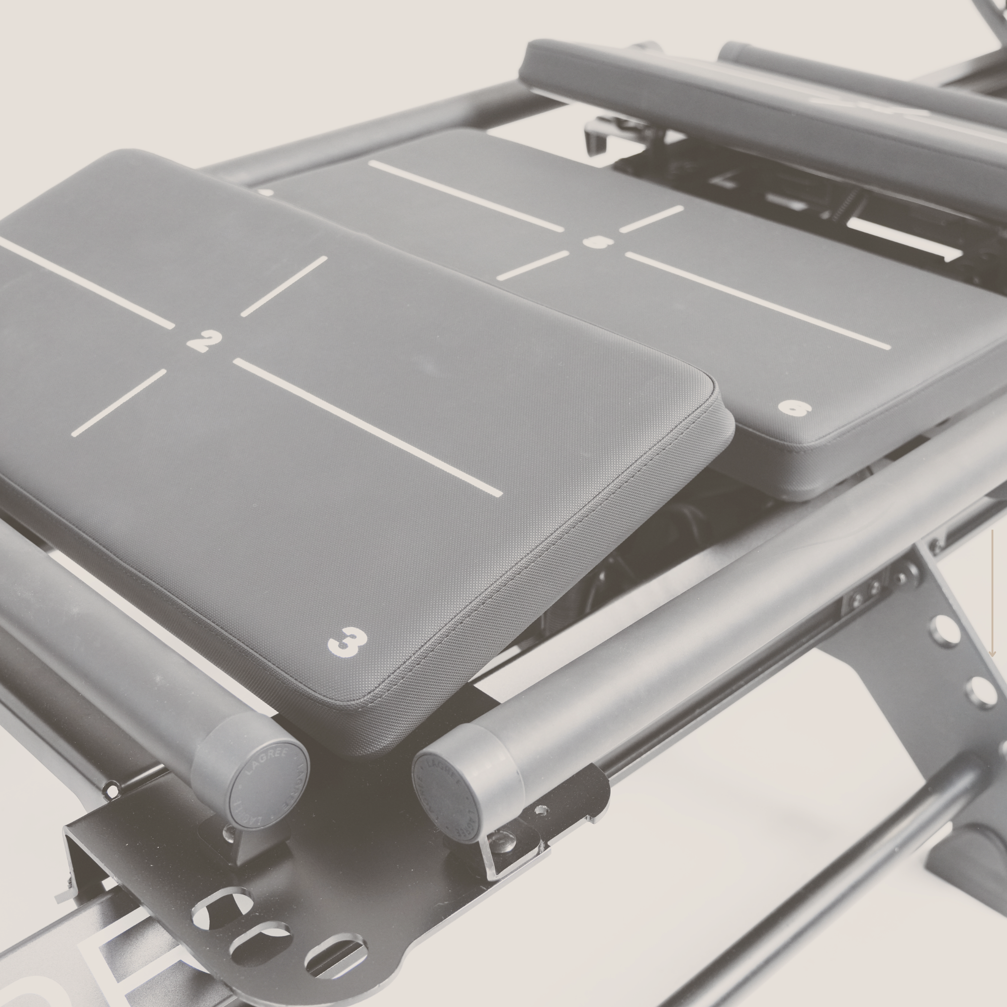 Close-up of a Pilates reformer machine with numbered padded platforms
