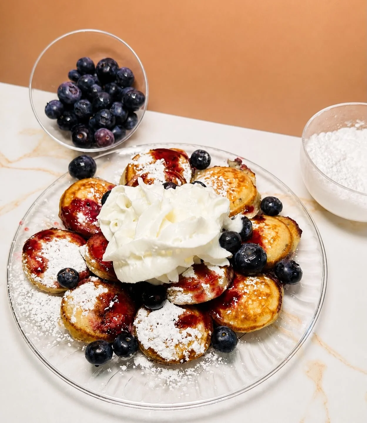 Blueberry Bliss 🫐 Fresh, vibrant blueberry flavor with a sweet, fruity finish. 

This delicious stack is topped with powdered sugar, fresh blueberries, a homemade blueberry sauce, and whipped cream 😋

#minipancakes #dmvtreats #dmvbrunch