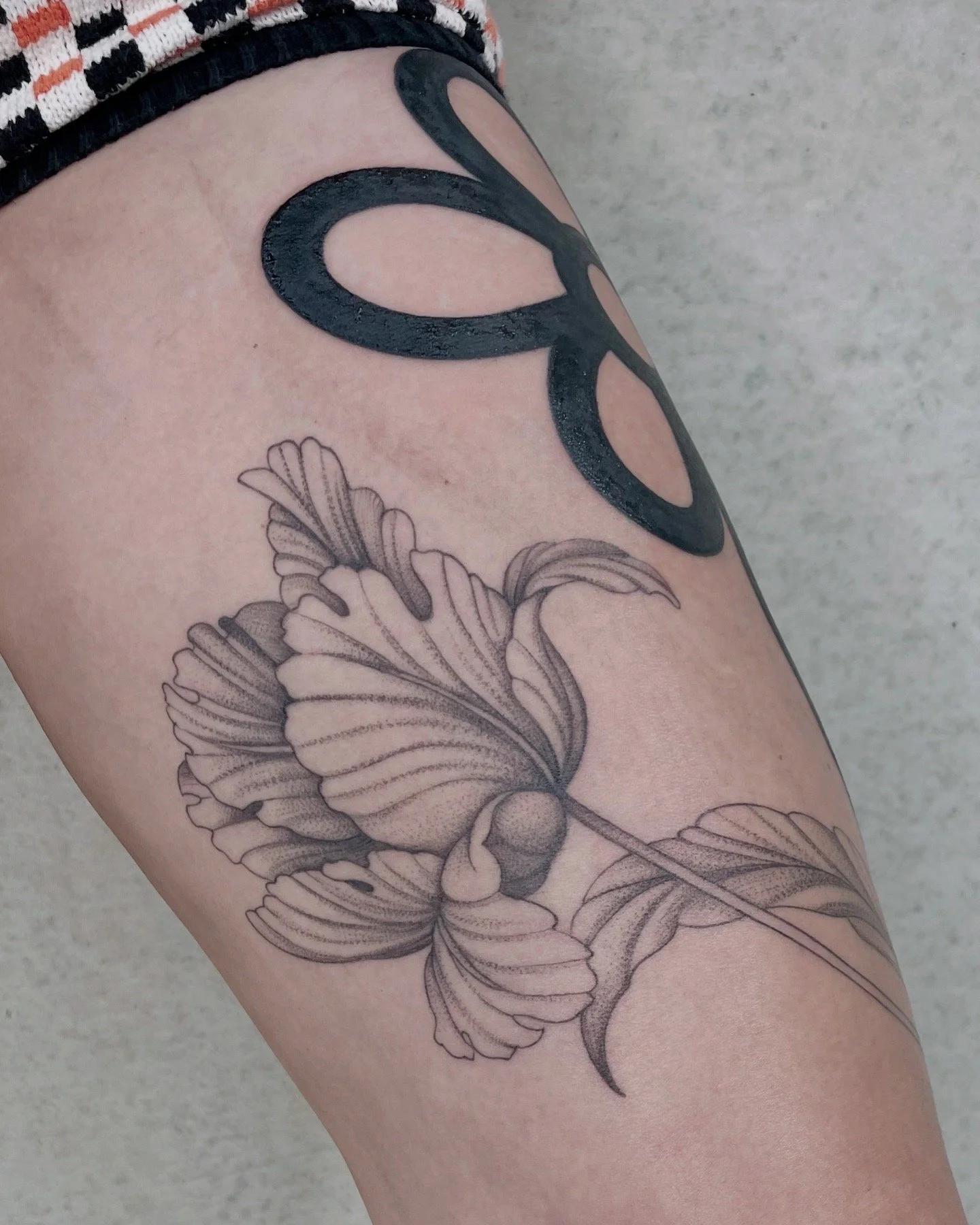 A tattoo on a person's arm features detailed black and gray butterfly wings with intricate shading.