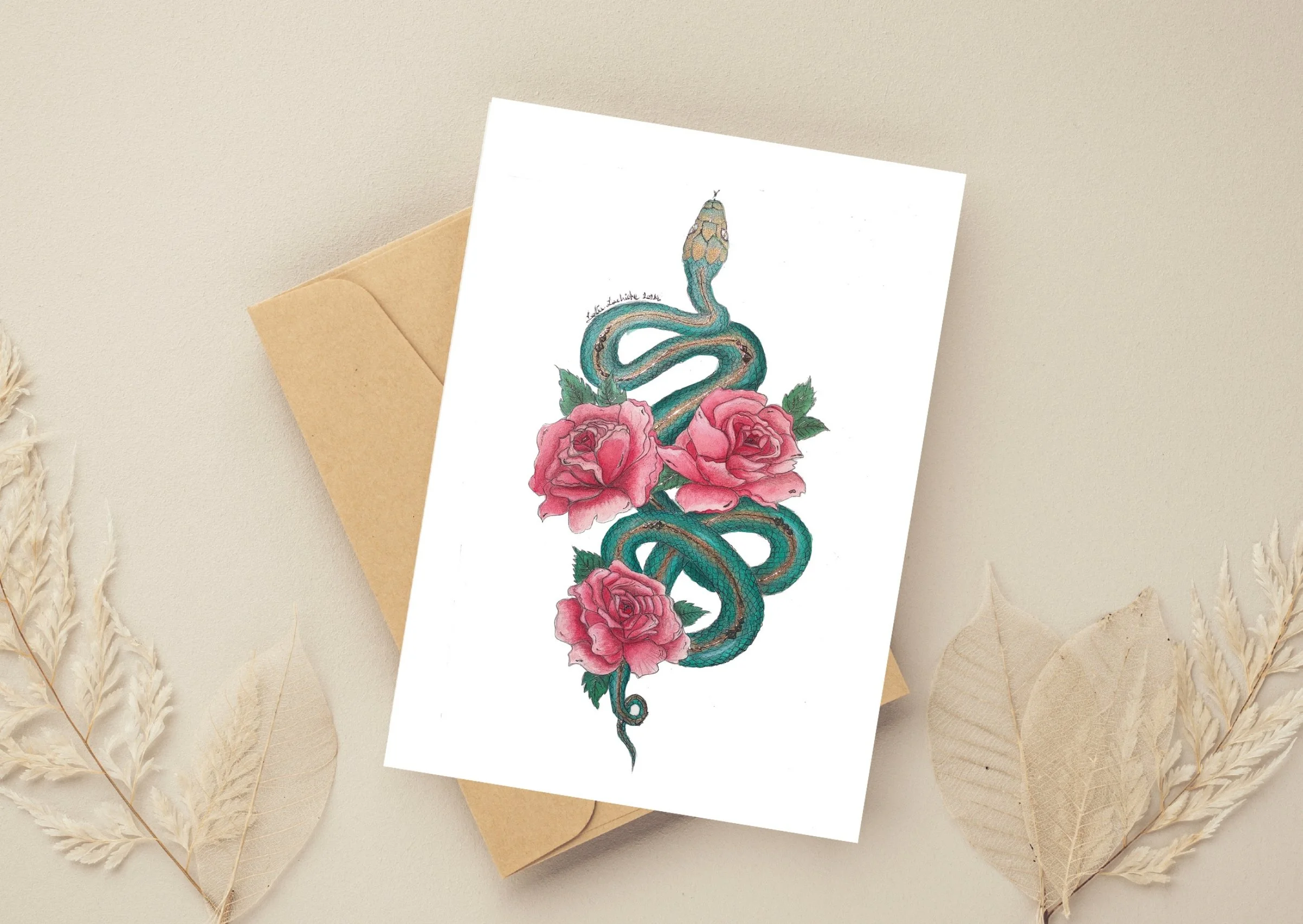Greeting card featuring a tattoo-style illustration of a snake intertwined with pink roses, void background, on top of a beige envelope with dried leaves around it.