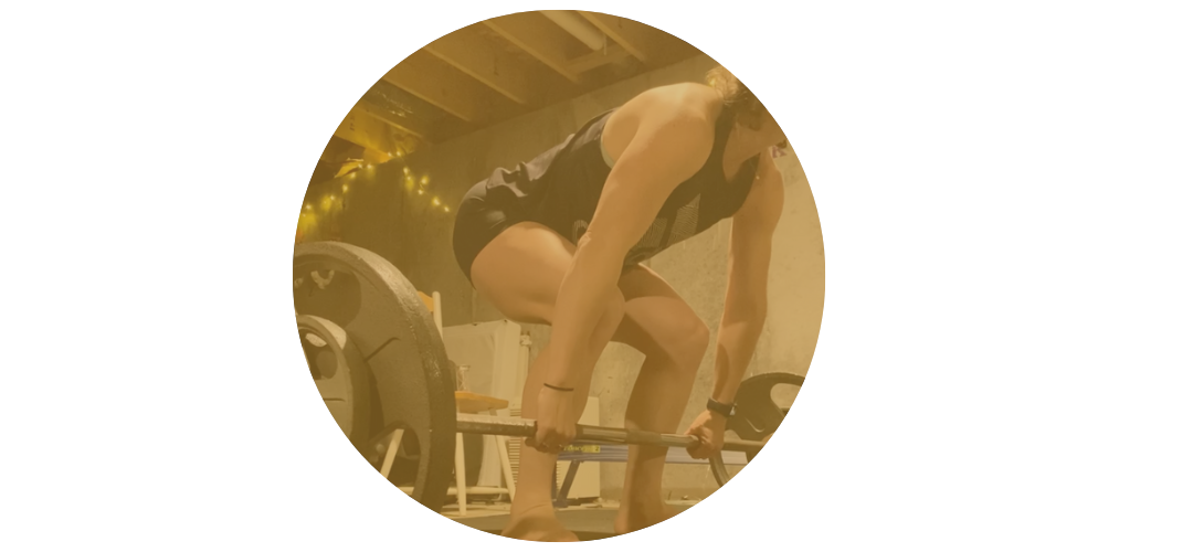 Burnout recovery coach performing a deadlift with a barbell in a home gym setting.