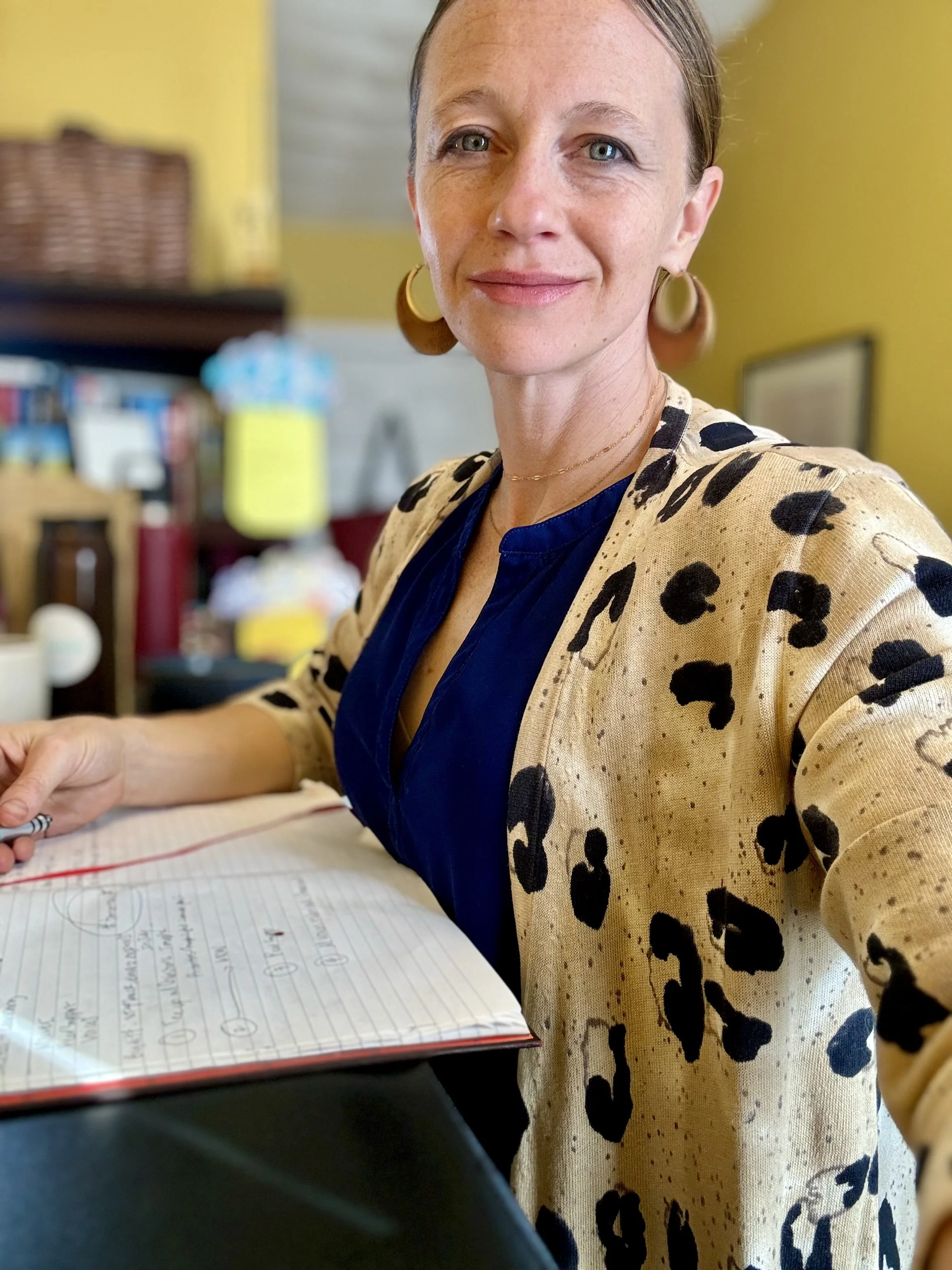 Burnout recovery coach holding a notebook in a home office
