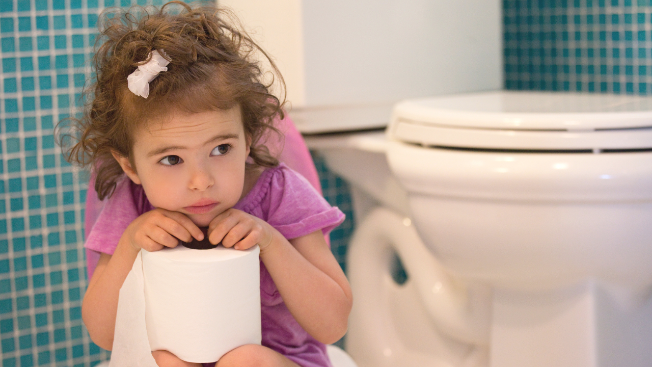 Little girl sitting next to potty appearing scared.