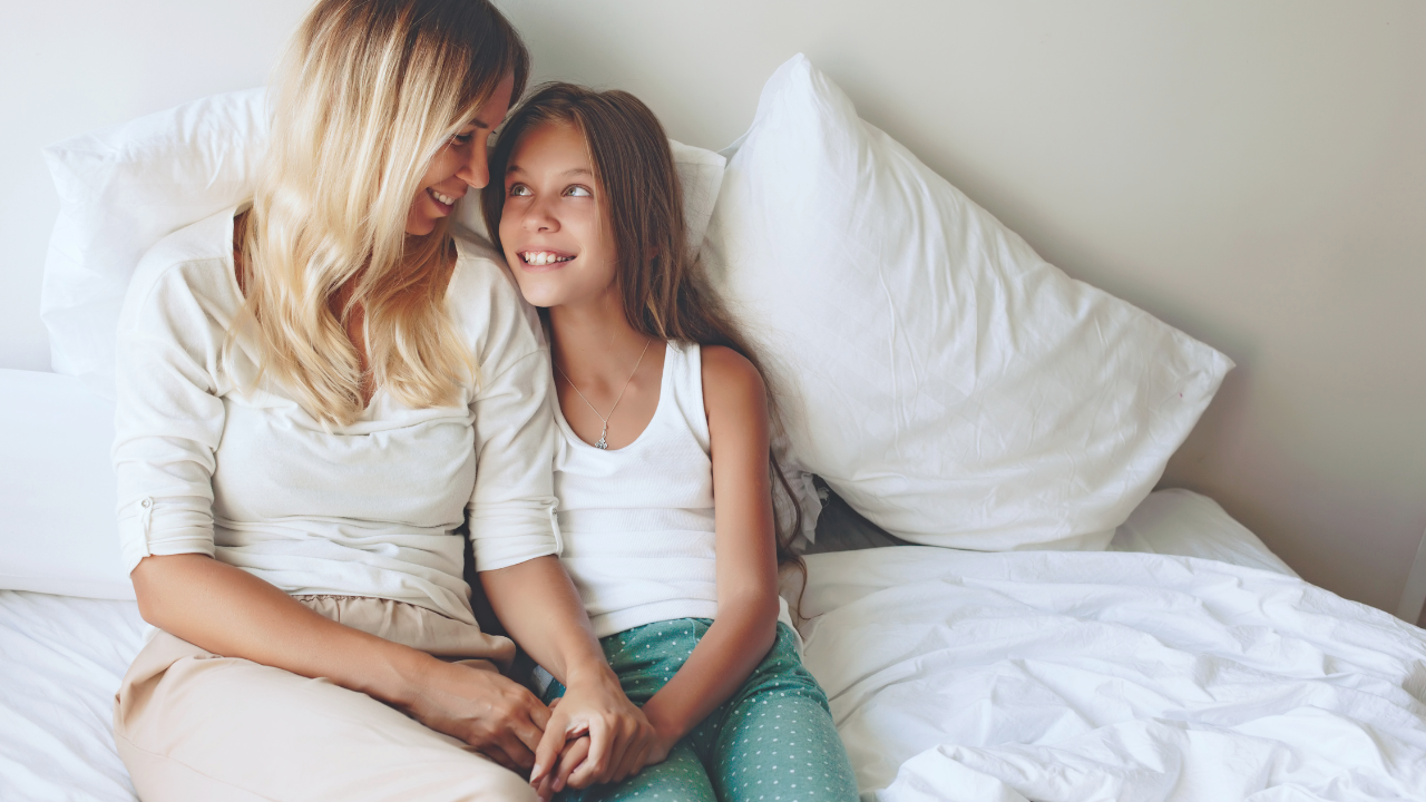 Mom and Daughter happily sitting together in bed