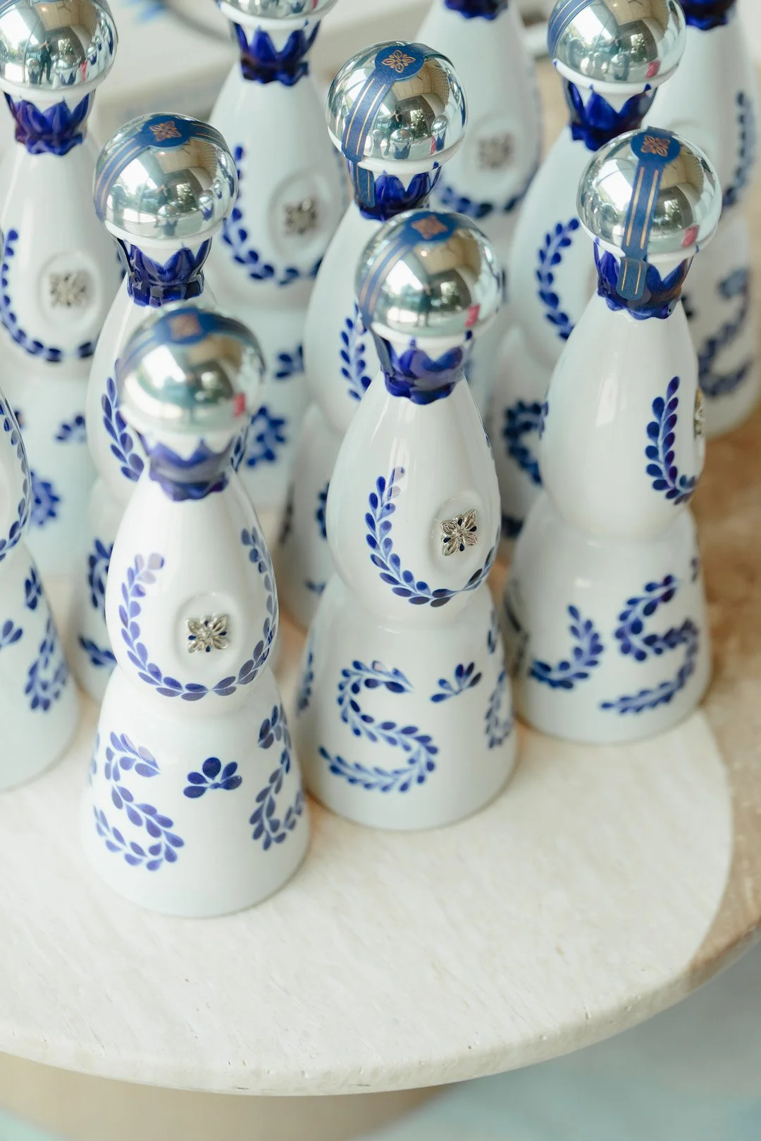 Decorative ceramic angel figurines with blue details and shiny silver heads displayed on a white surface.