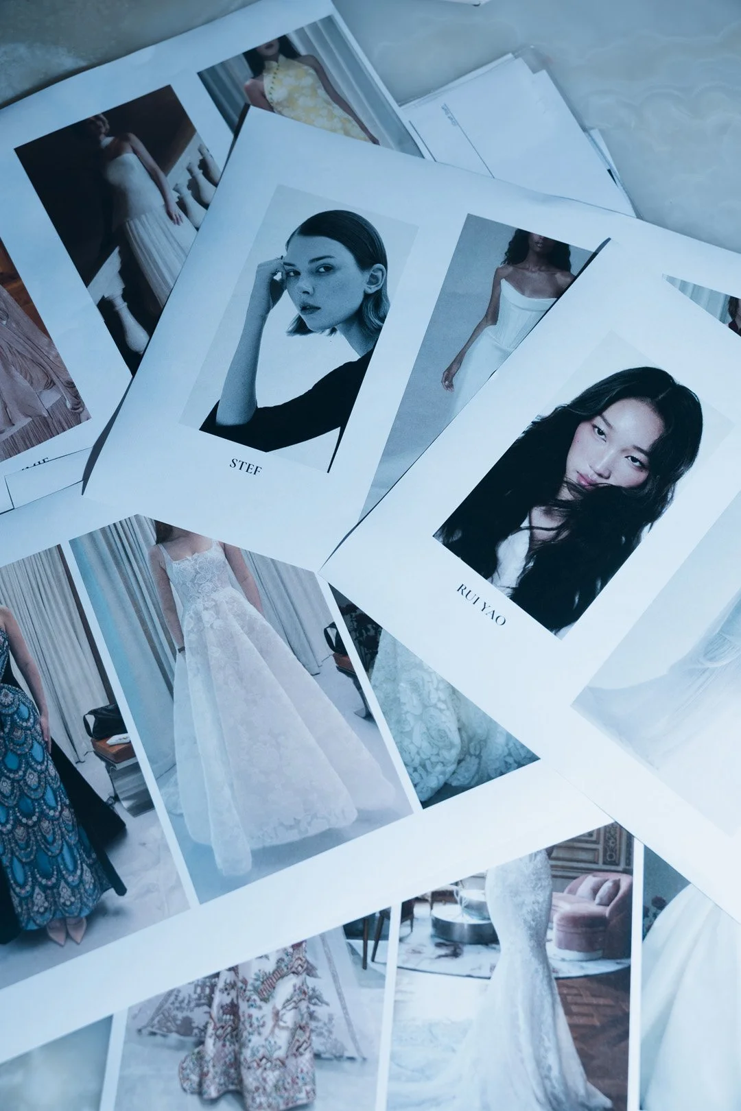 Printout pages with fashion photographs, including models and dresses, featuring mostly portraits of women with some images of dresses on models.