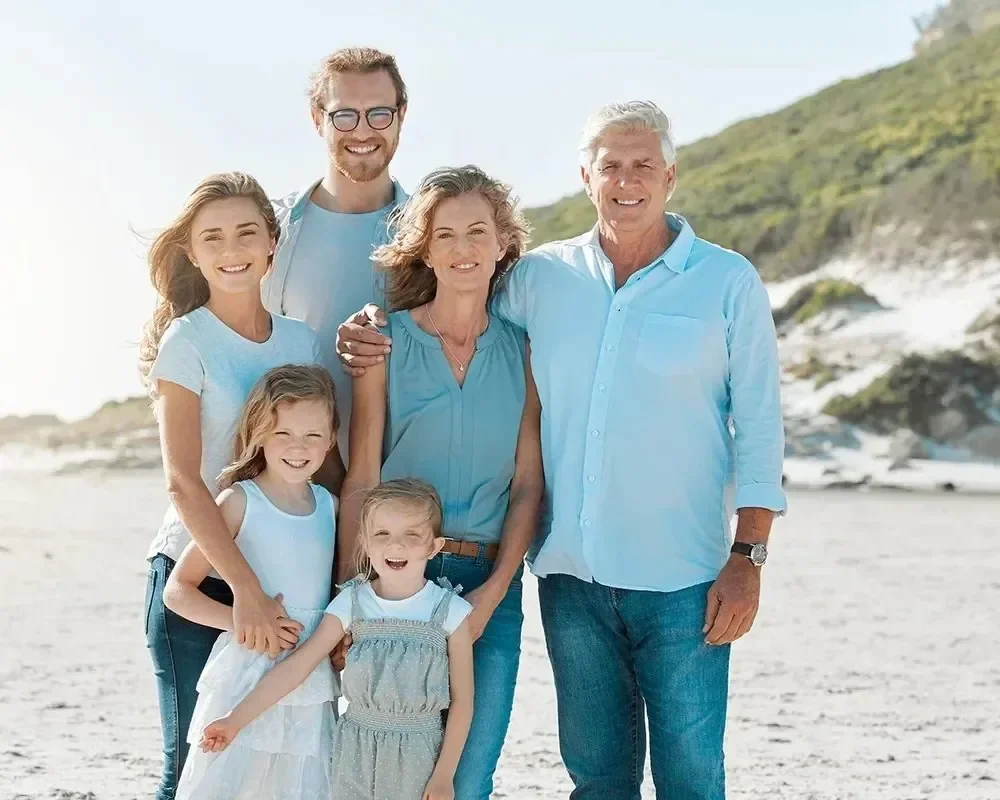 Multigenerational family at the beach smiling together