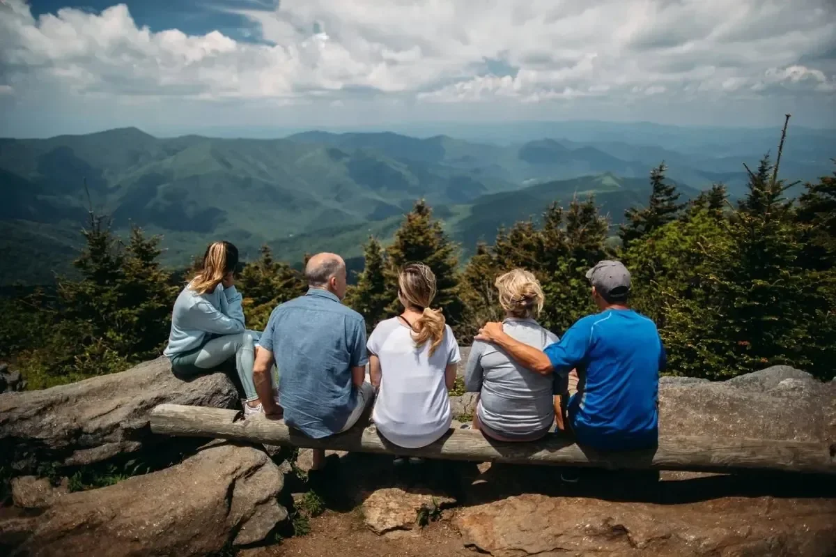 Family seated on a mountain overlook enjoying the view together