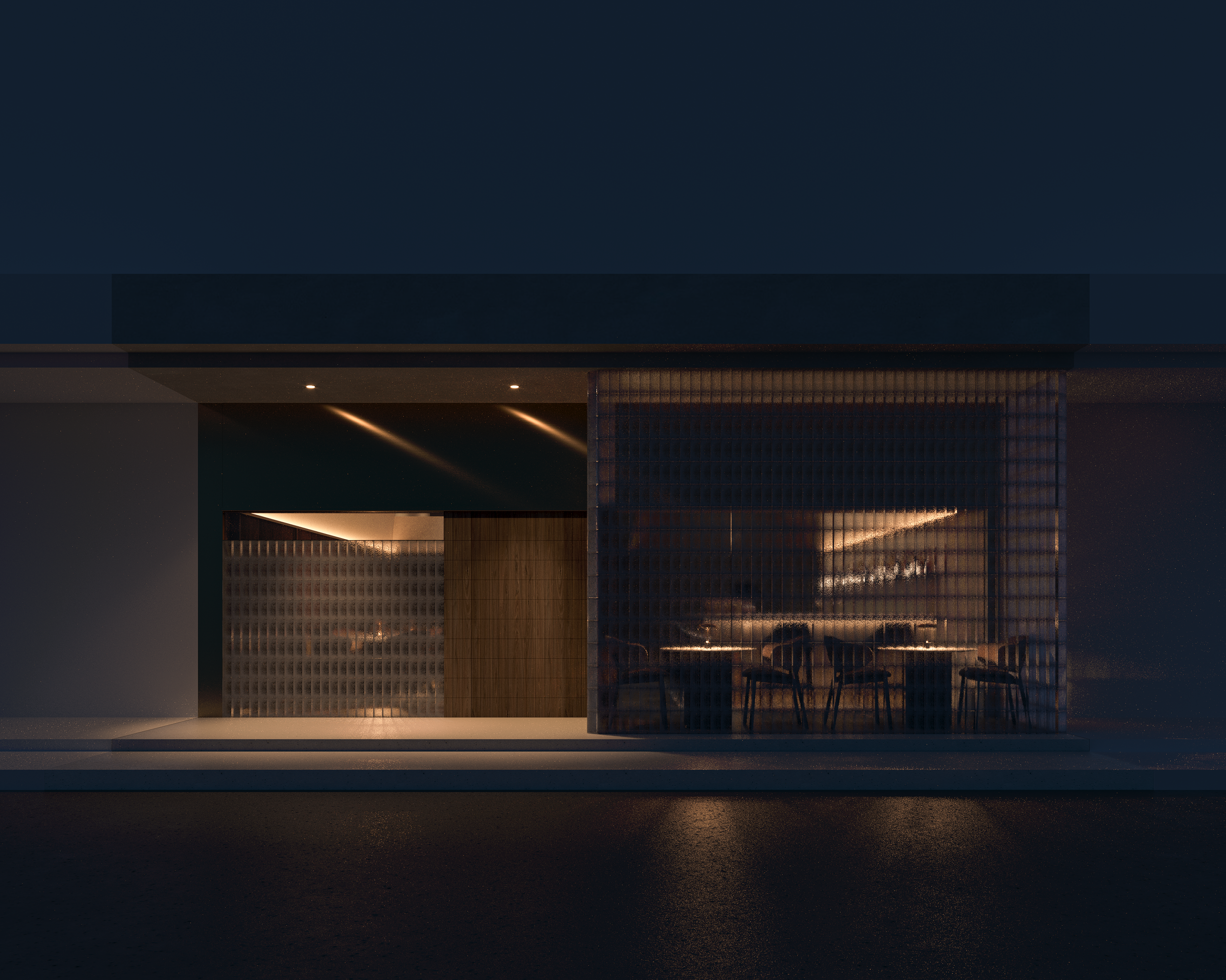 Night view of a modern building with large glass windows showing a dimly lit indoor space with tables and chairs.