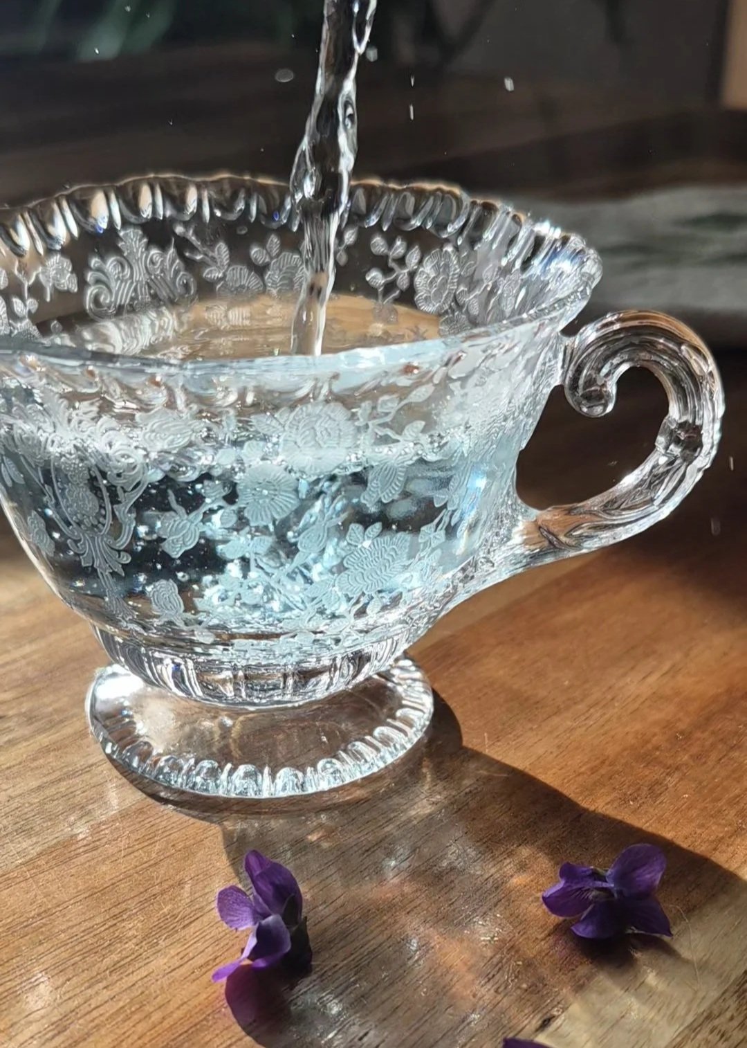 pale violet tea pouring into an etched glass cup