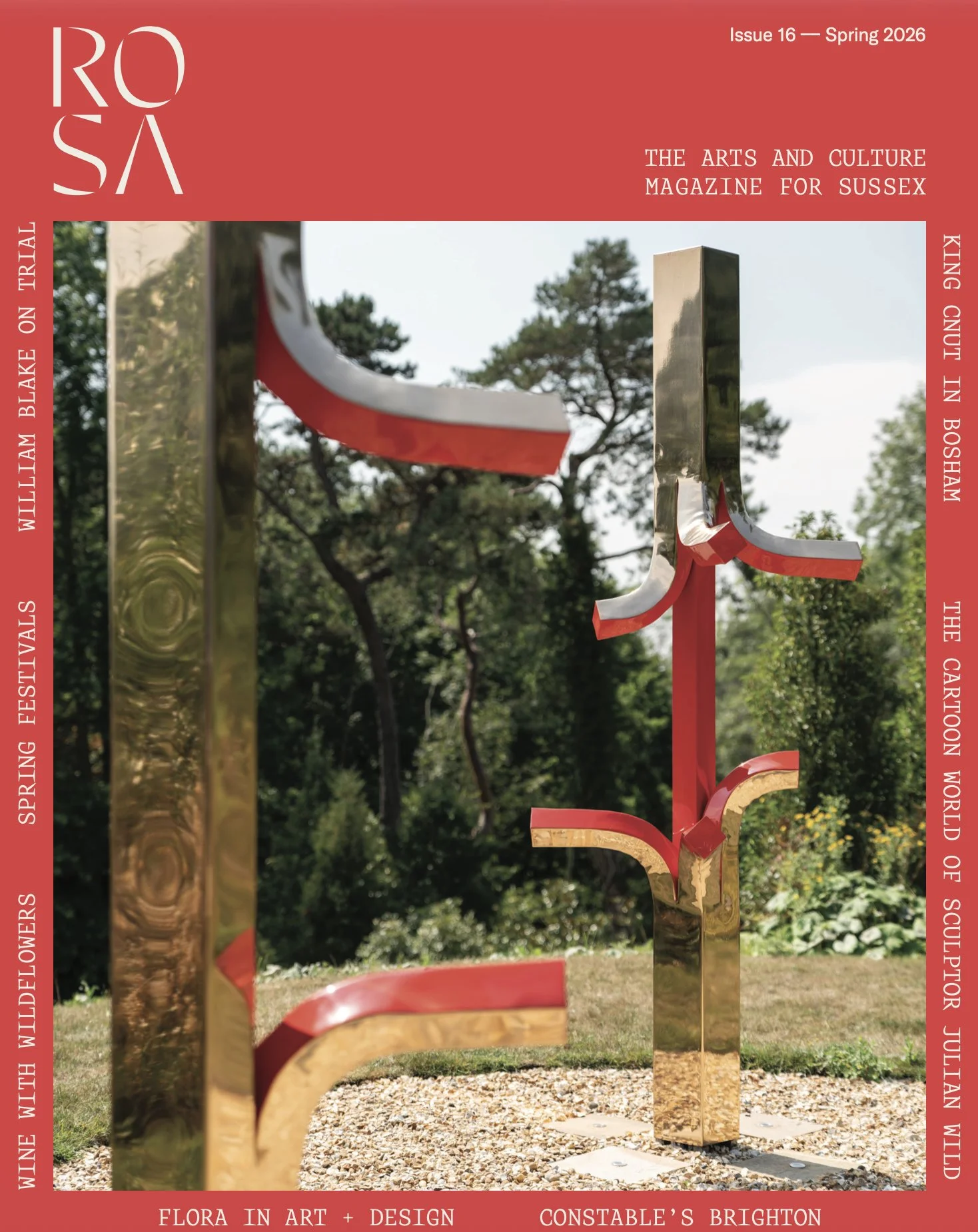 A magazine cover featuring an outdoor sculpture of abstract metallic shapes with red accents, set against a background of trees and green foliage.