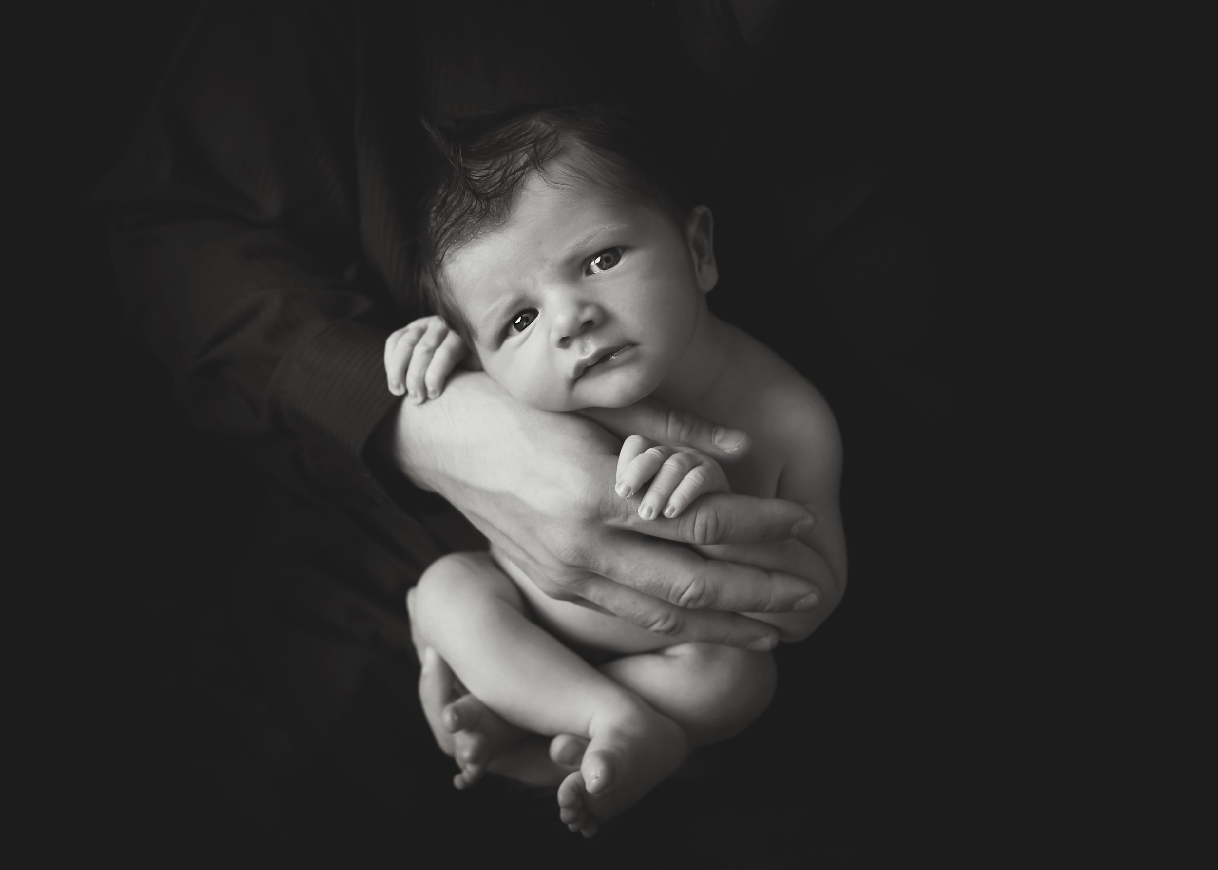 baby in dads hands awake