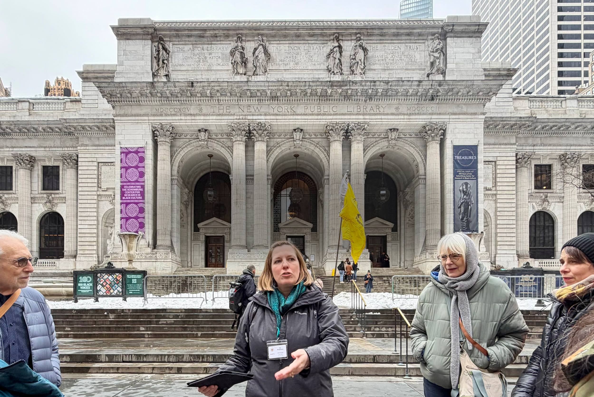 Tour guide with small group in front of the New York Public Library.