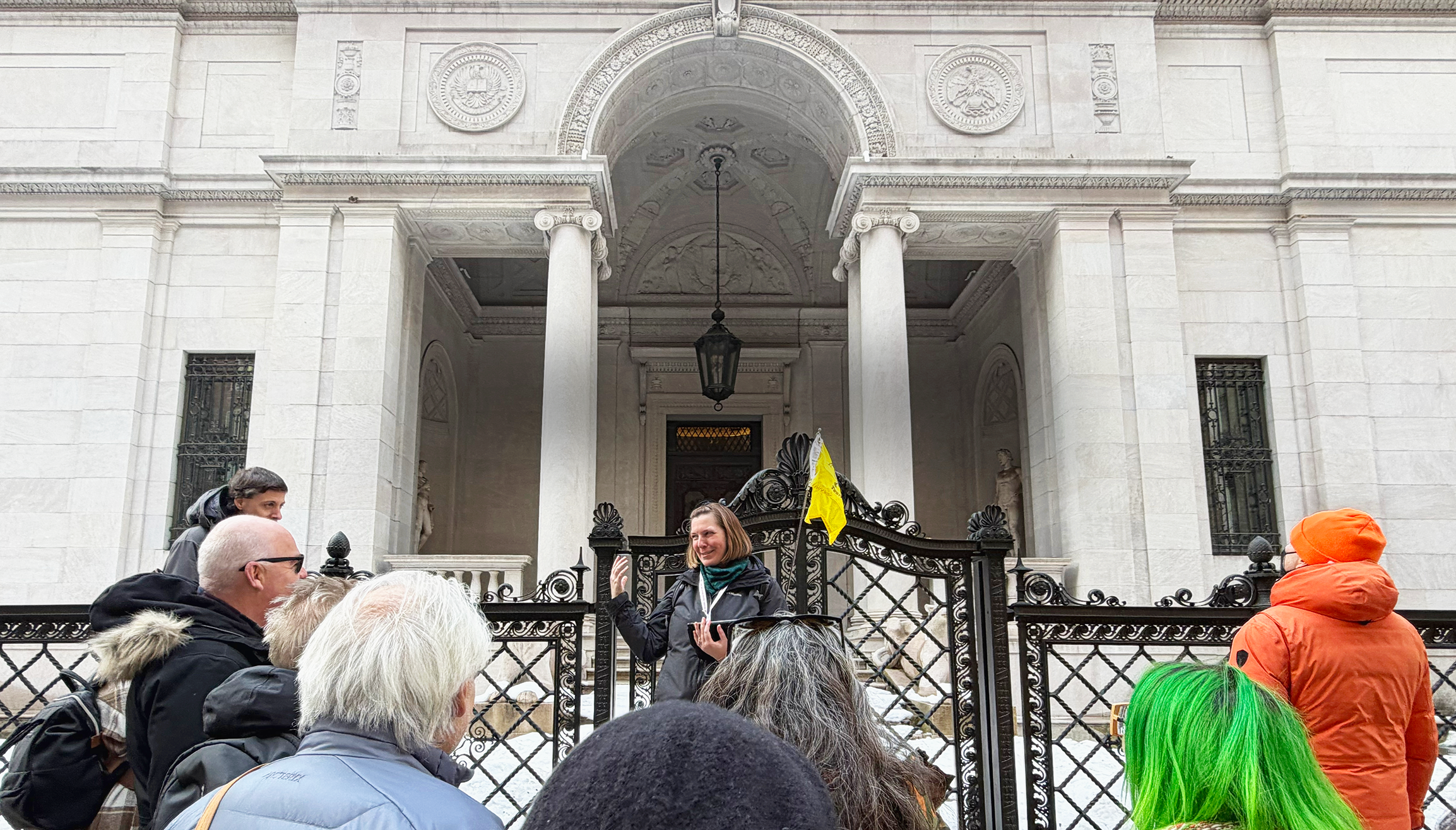 Tour guide recounting a story to guests in front of the Morgan Library.