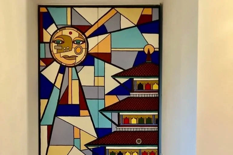 Vitrail coloré représentant un visage stylisé avec un temple asiatique en arrière-plan.