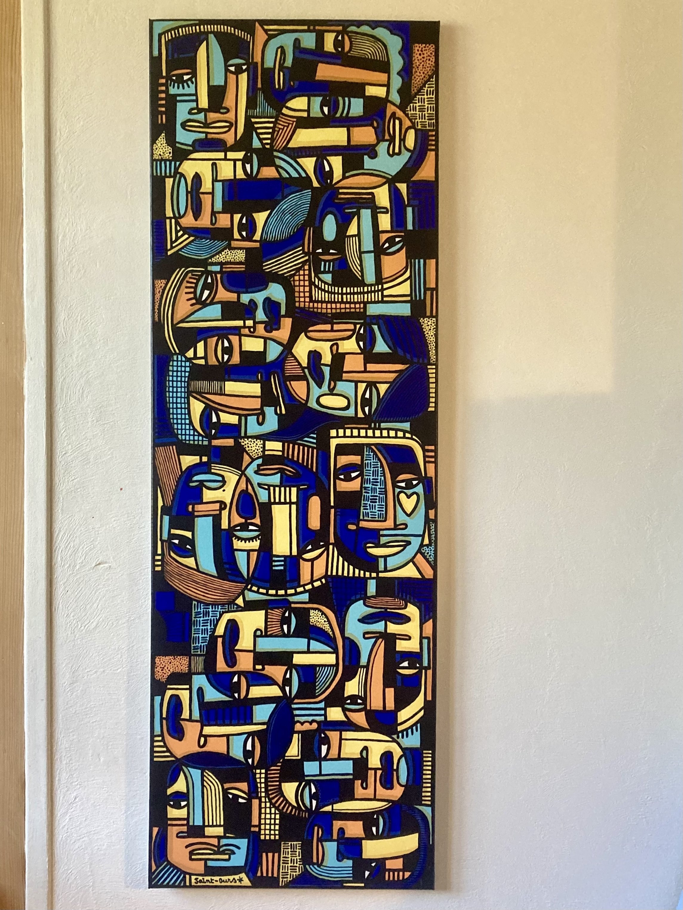 Peinture abstraite représentant de multiples visages stylisés en couleurs bleu, jaune, noir et beige, avec des formes géométriques et des détails fins.