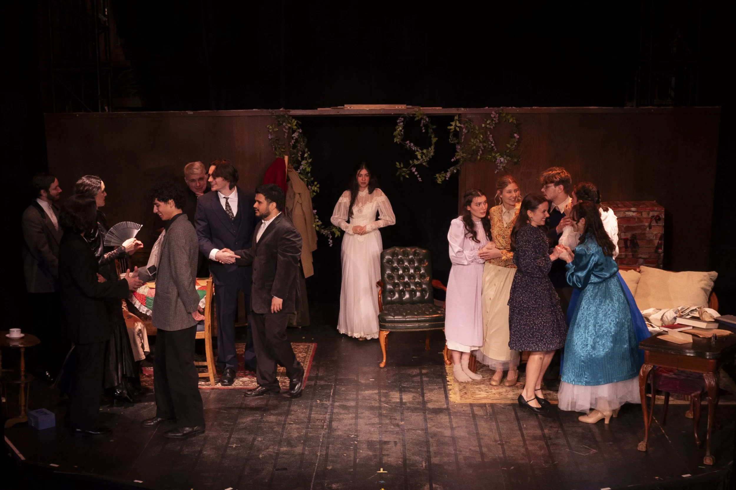 A photograph from the play Little Women. Theatrical performance scene with actors in period costumes on stage, engaging in dialogue and interaction.